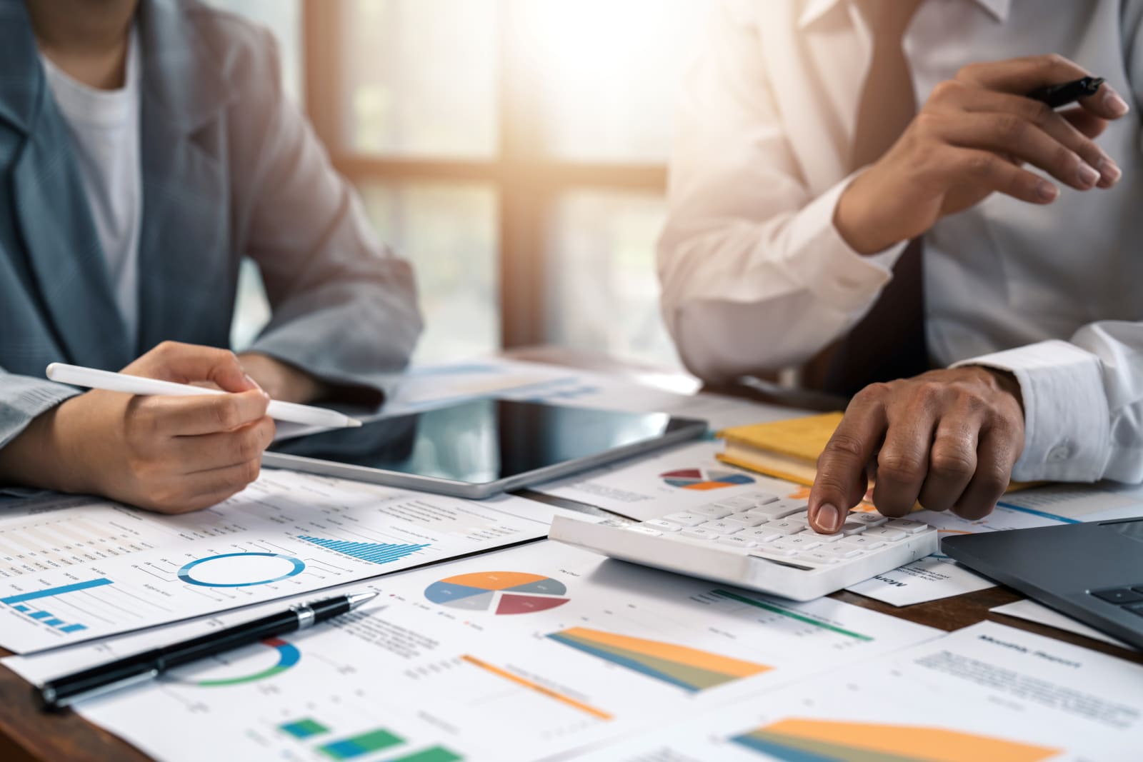 people sitting at a desk looking at graphs and documents