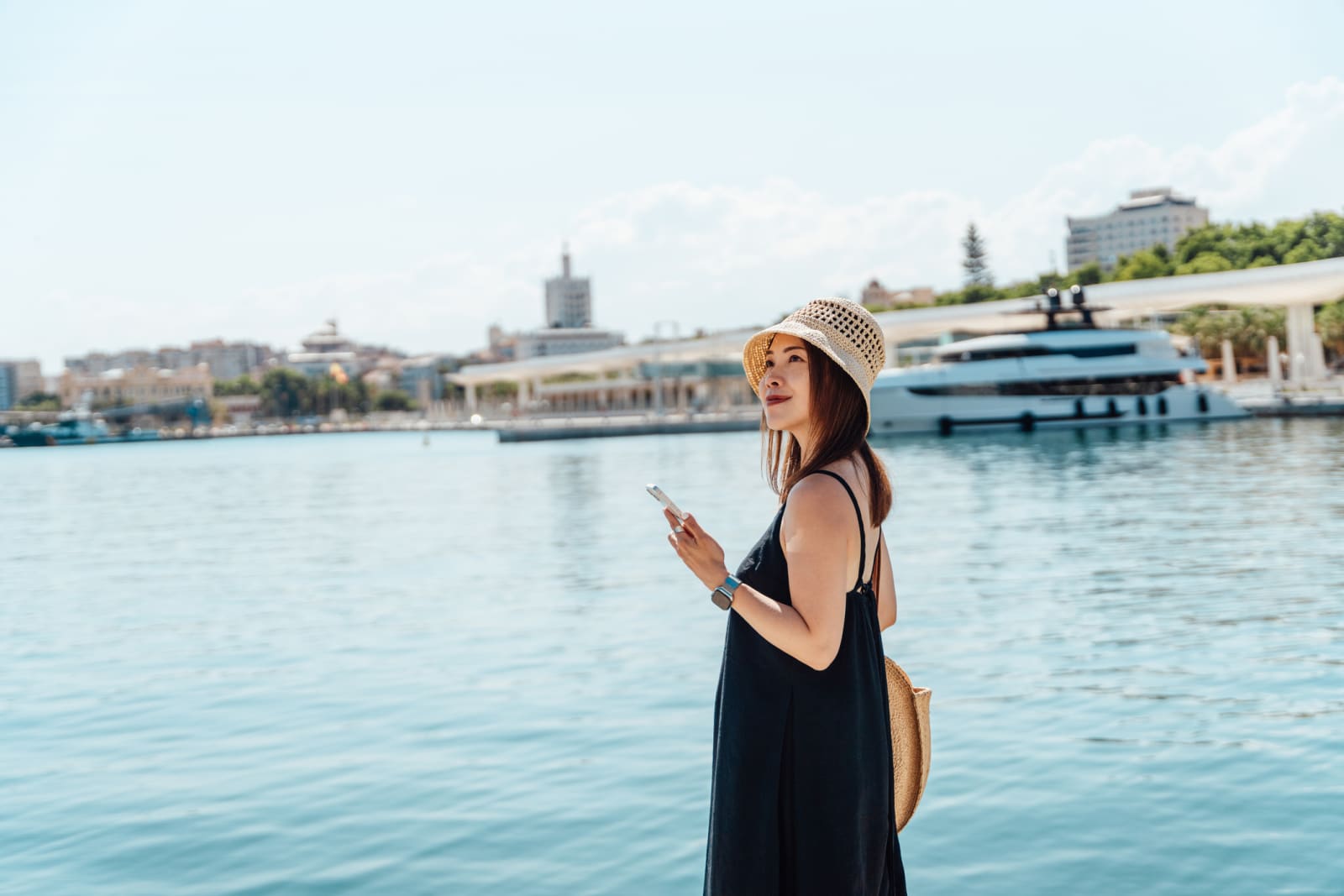 lady holding phone and smiling at cruise terminal