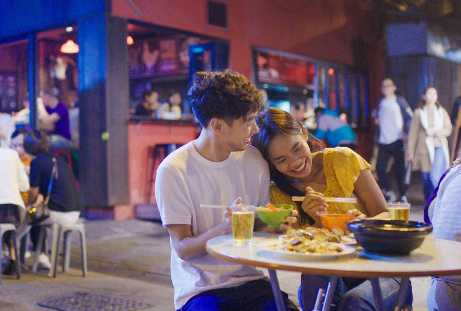 A young couple enjoy beer with their meal at a bar