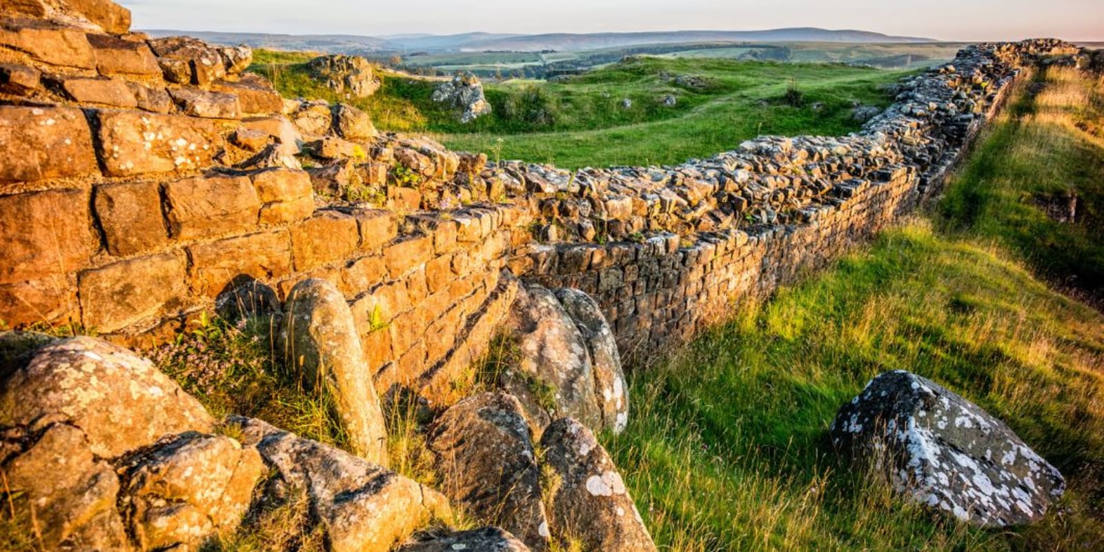 Hadrain's Wall, a long stone wall with green grass on either side.