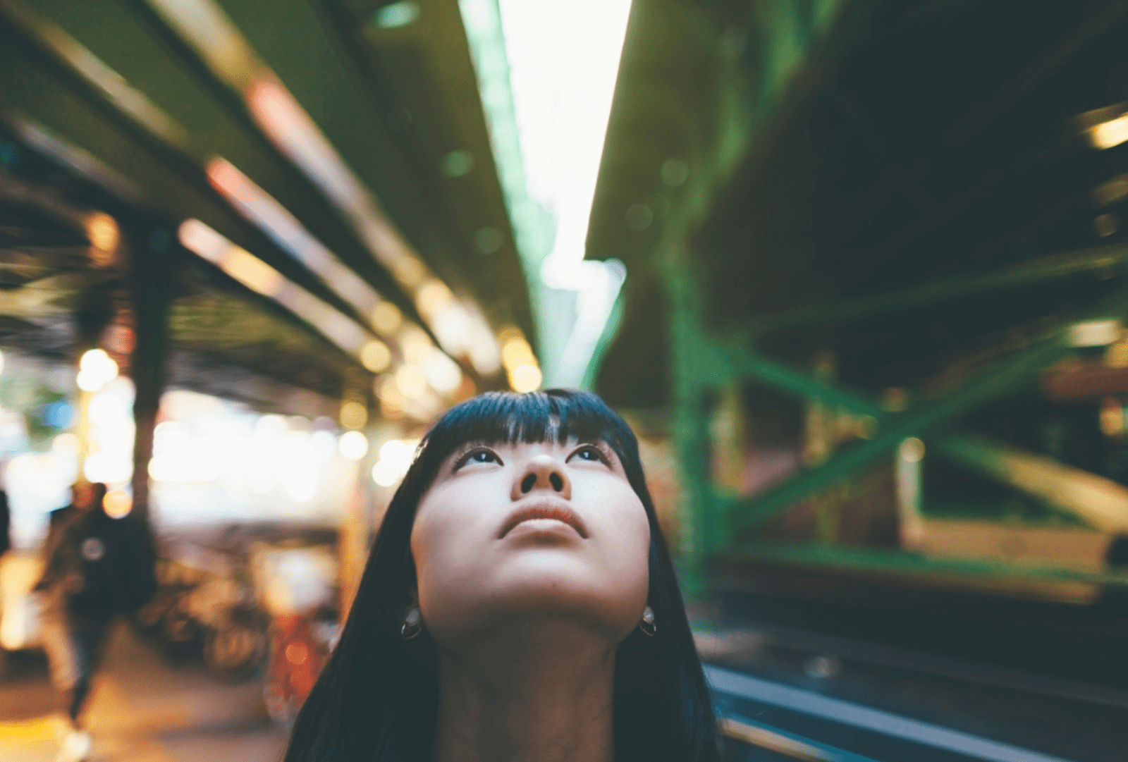 A woman on a Japanese street looks up.