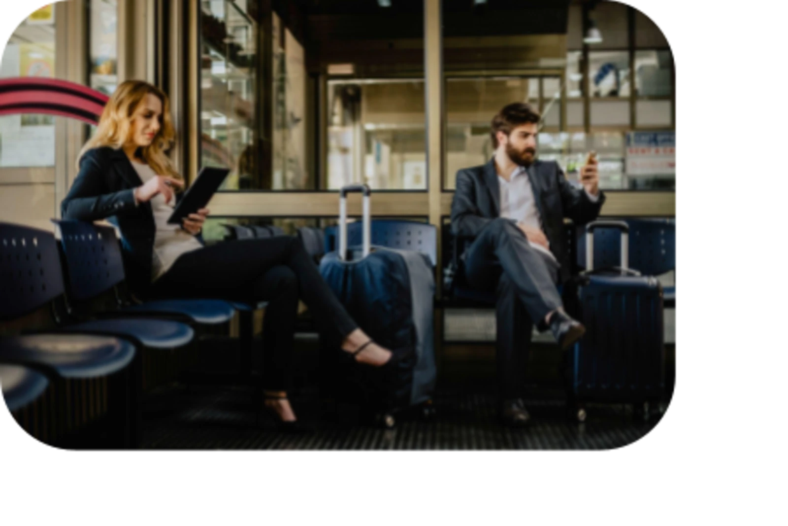 woman seating using laptop and man seating using phone