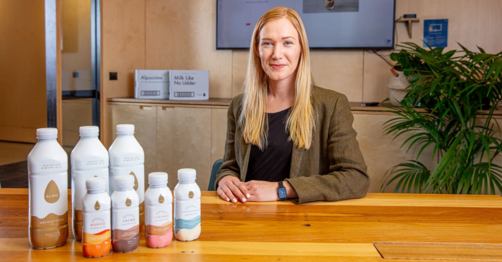 Spokeswoman for Almo Milk sitting with several bottles in a conference room