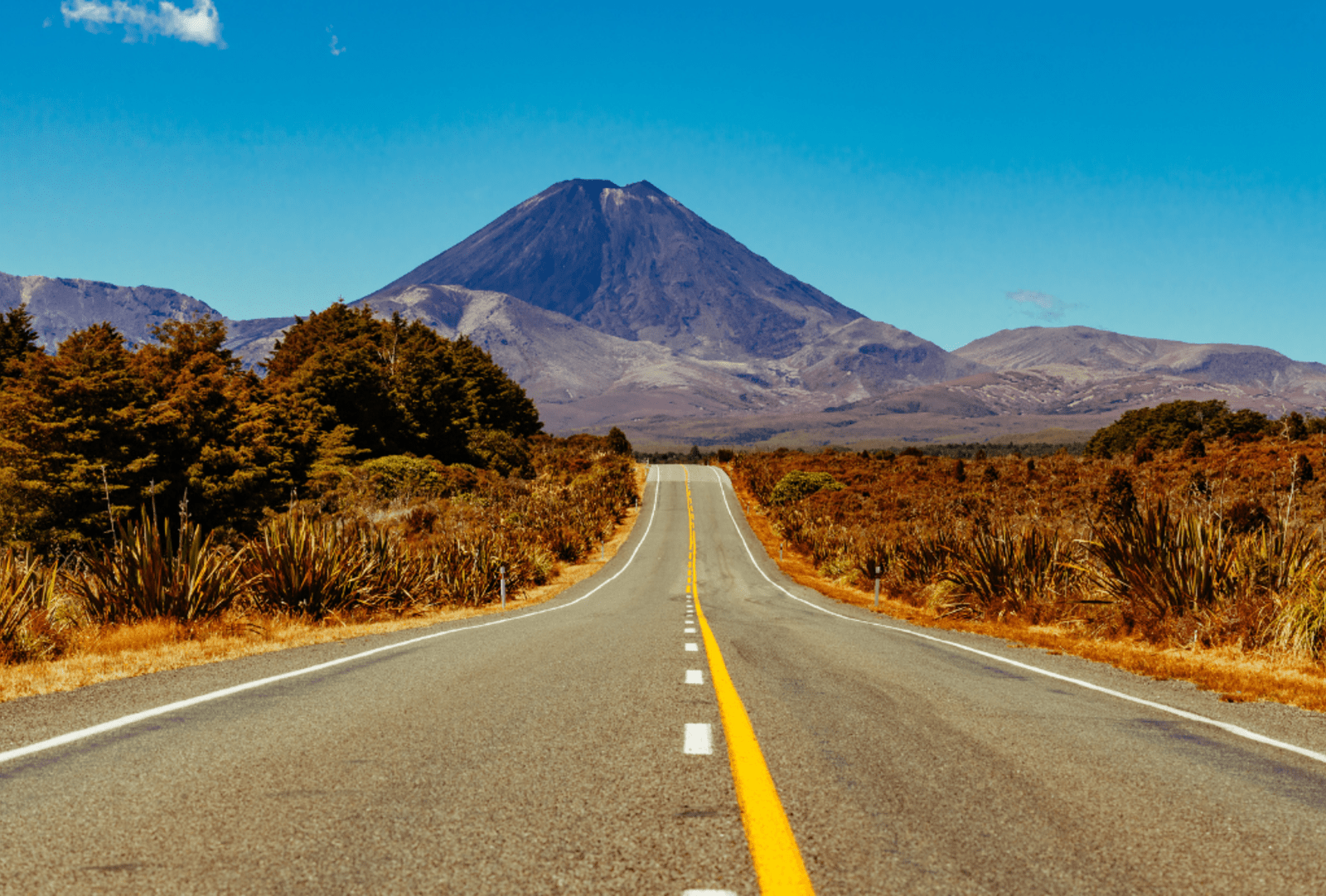 A view of Mount Ngrāuruhoe at the end of a straight road