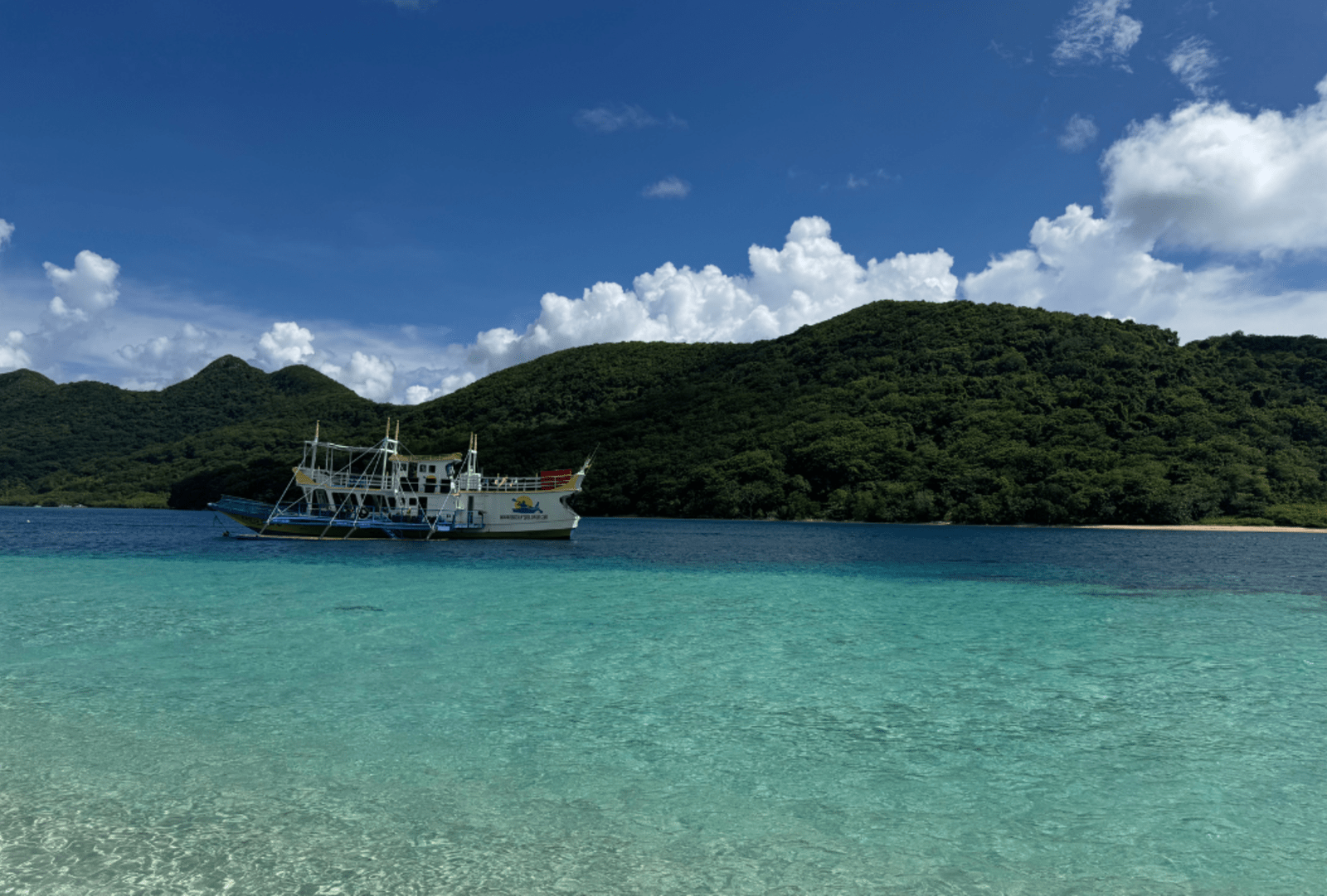 Crystal clear waters and a tour boat, Palawan Islands.