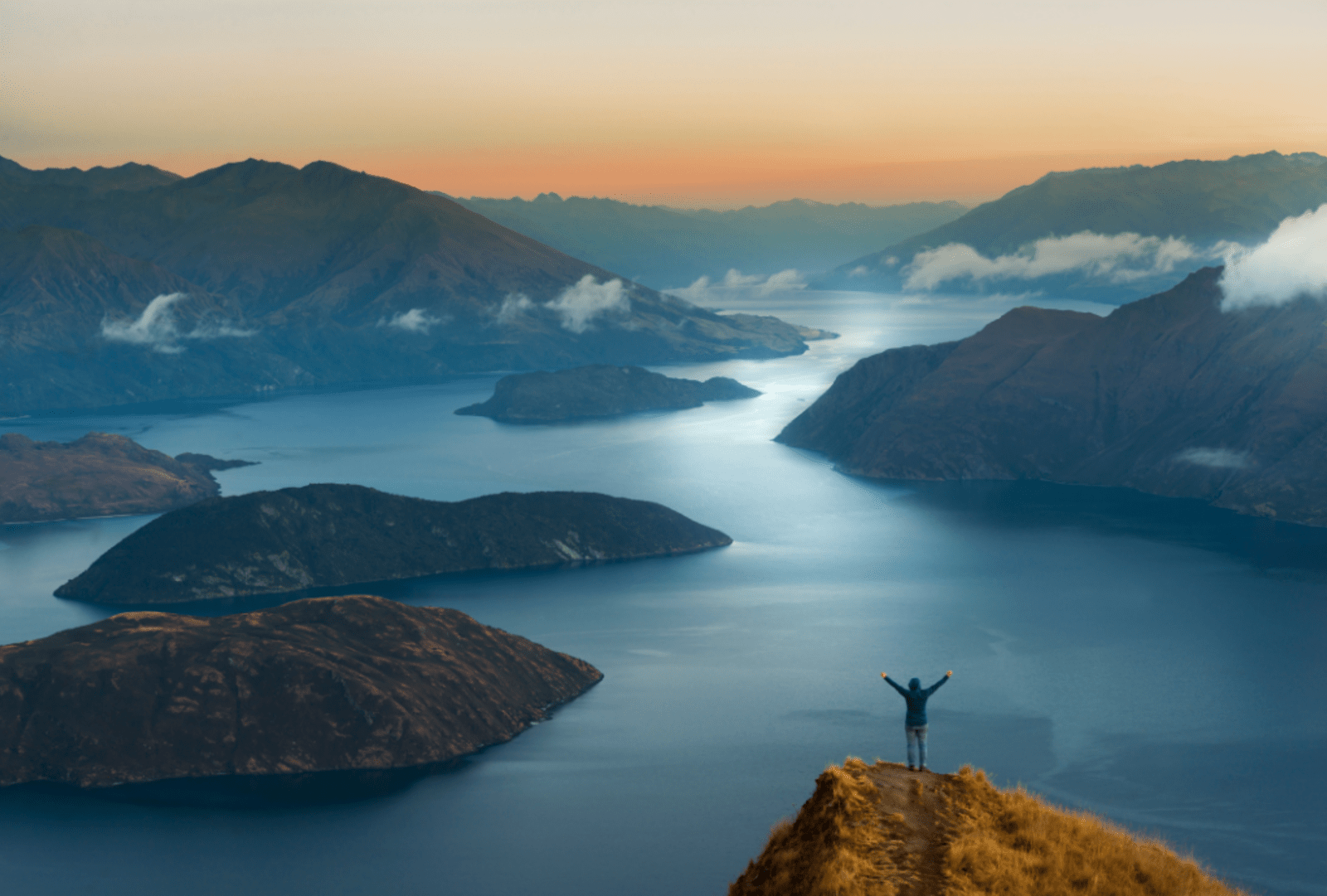 Woman overlooks Lake Wanaka from Coromandel peak at sunrise
