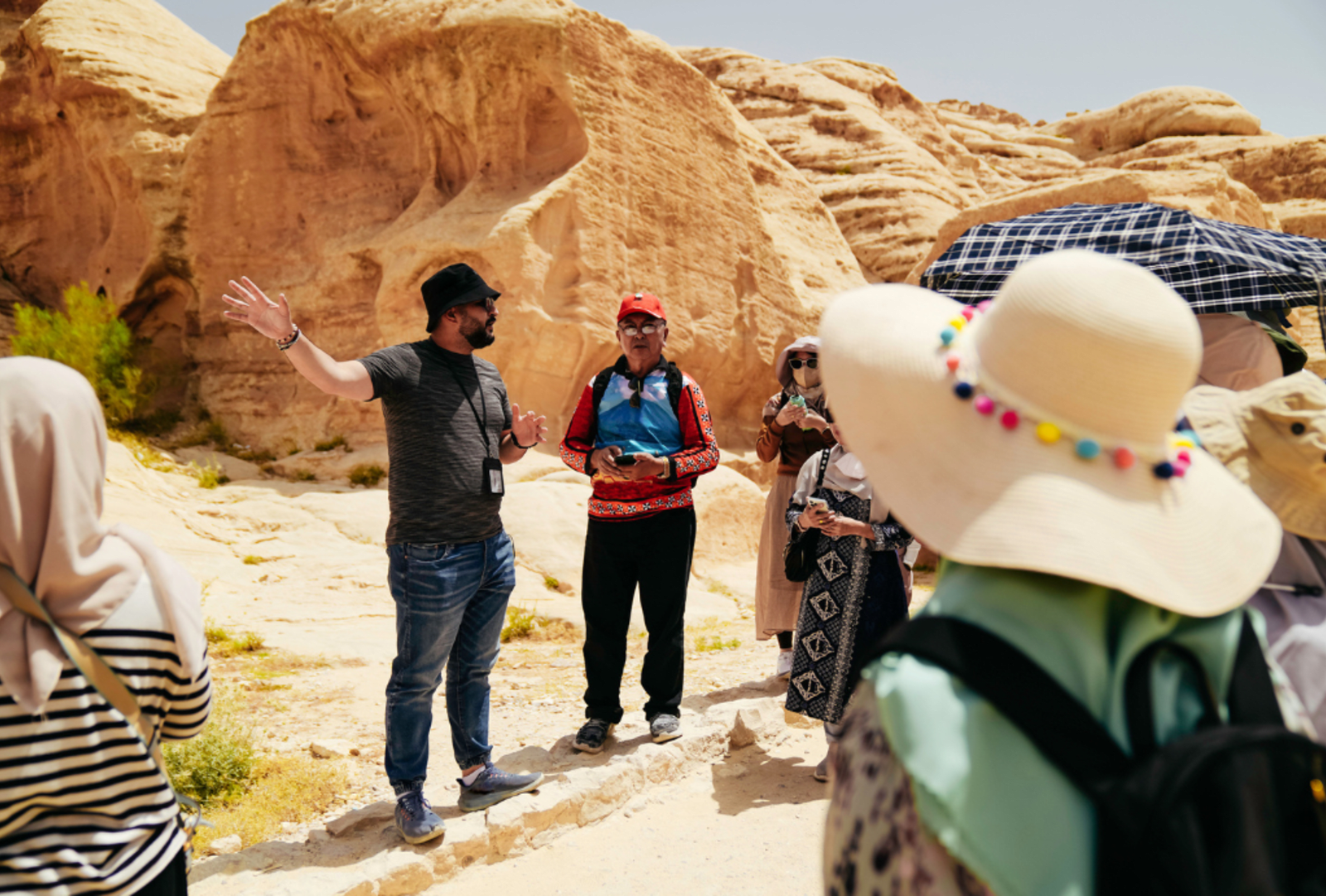 People listen to a tour guide in the desert