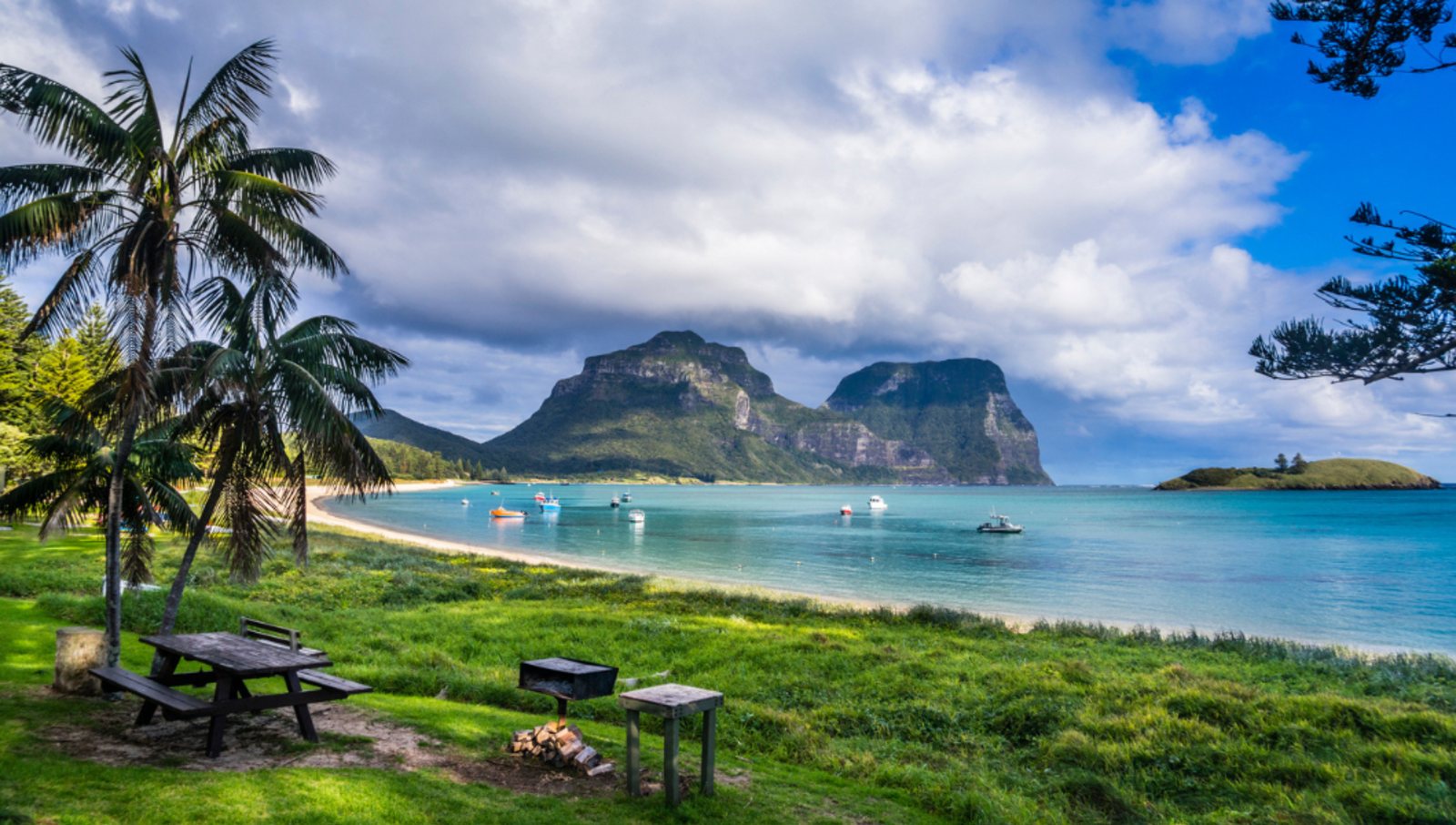 Coast surrounding bright blue cove with mountains in distance