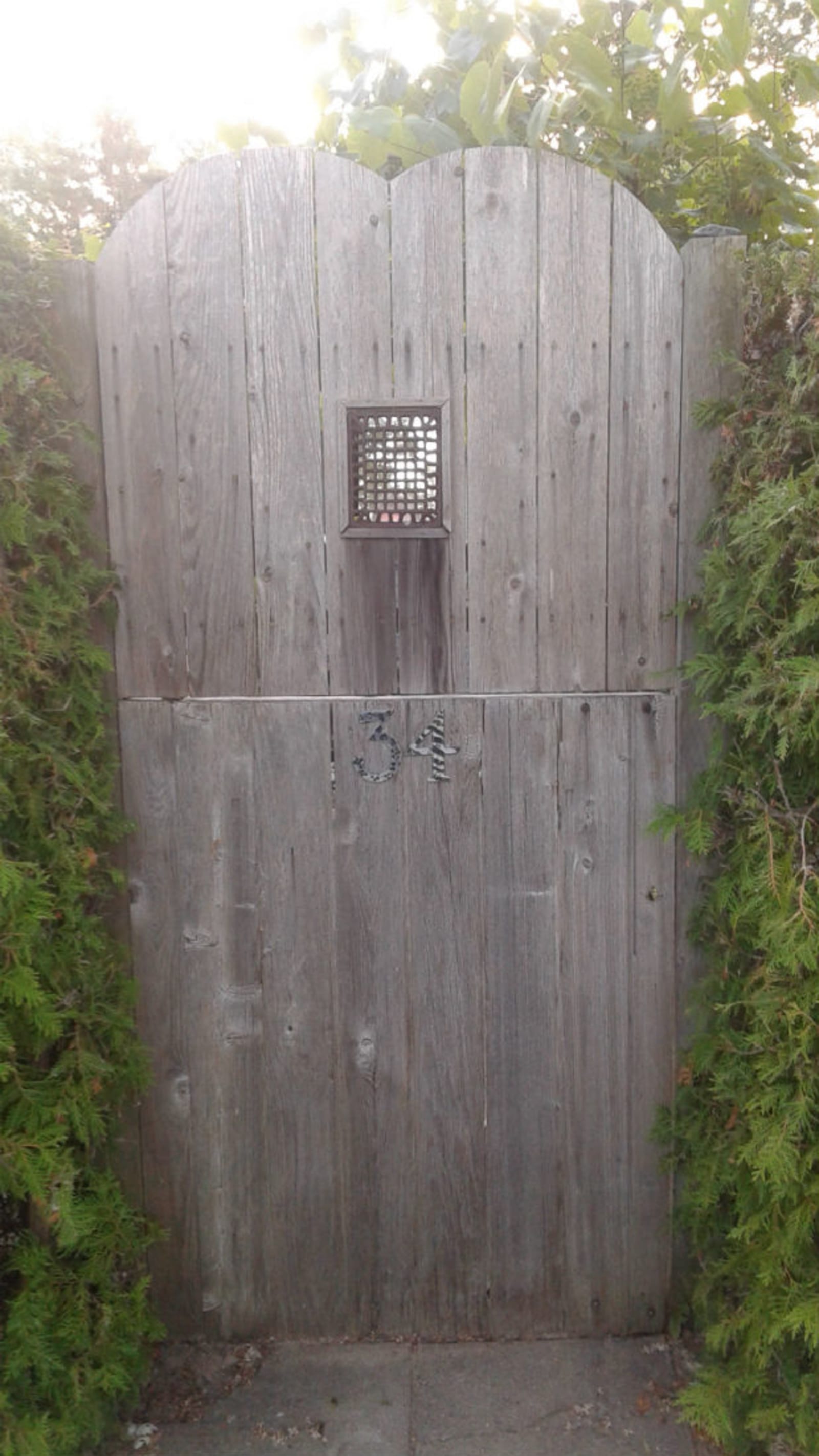 Wards Island House - Large wooden gate in a backyard with a heart-shaped top