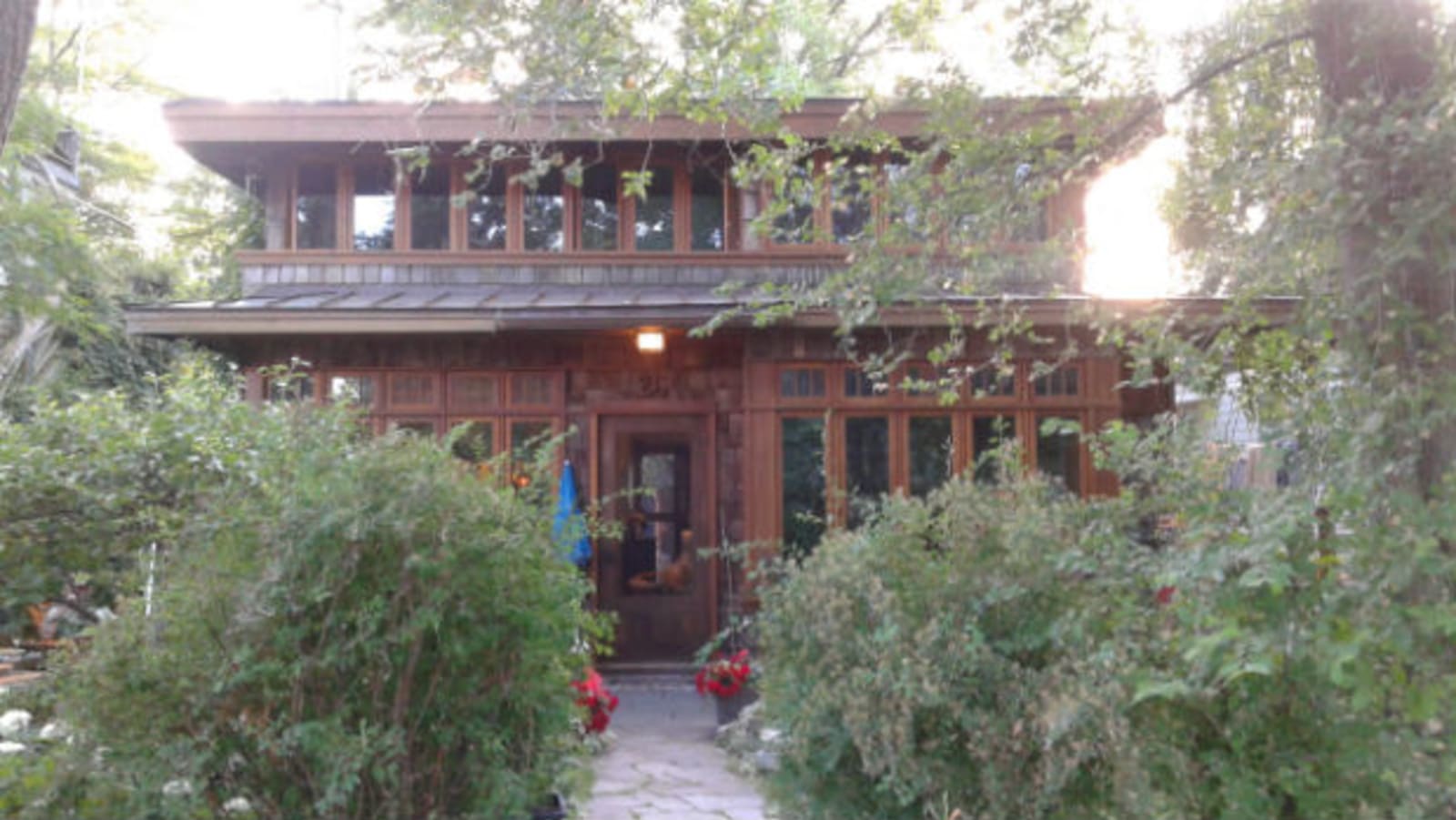 Wards Island House - front door view, large open windows and lush shrubbery