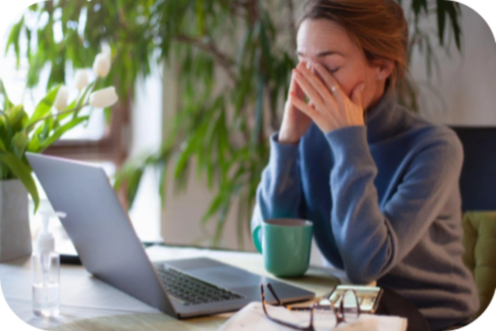 lady sits in front of a laptop and looks like tired