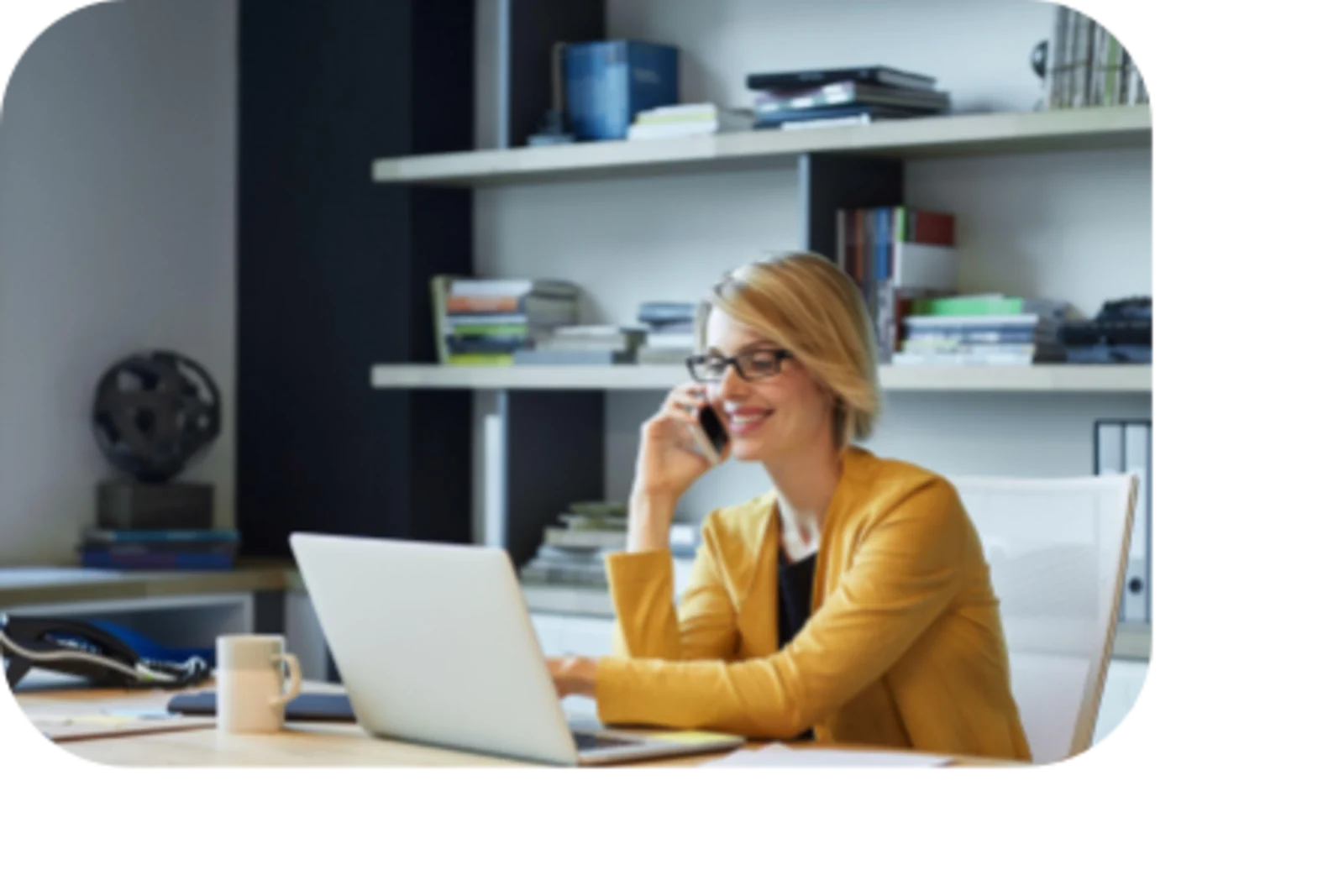 woman talking at phone and using laptop with a smile