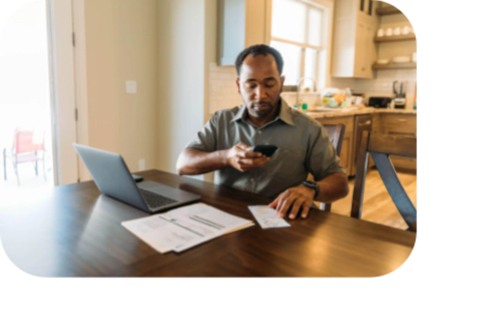 man taking photo of a document in front of laptop