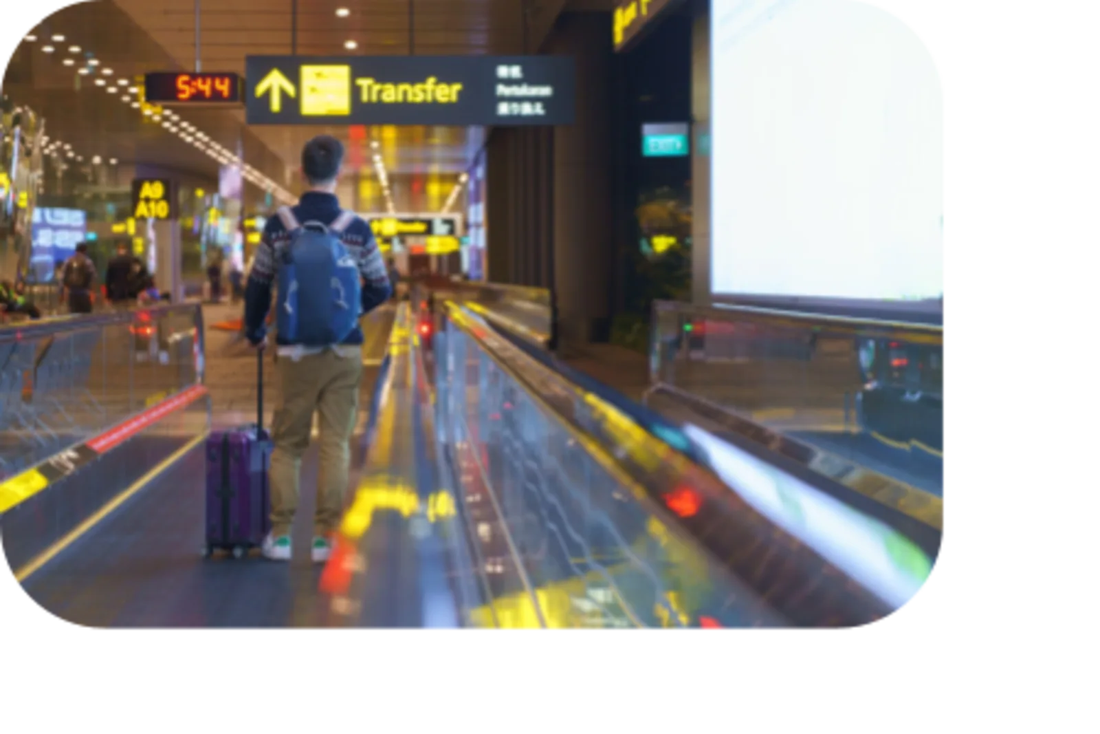 man using escalator and carrying luggage in airport