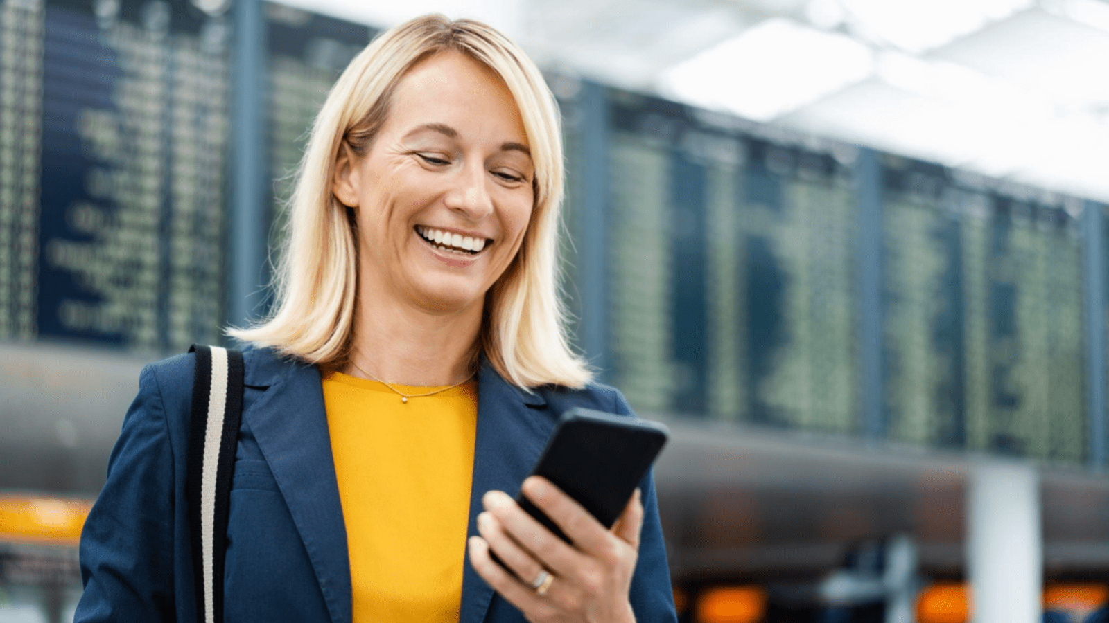 lady in airport smiling at phone