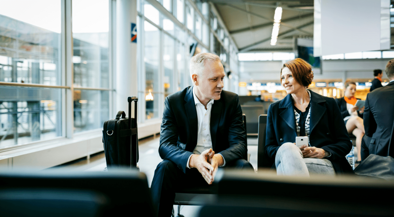 two business people sitting together in airport