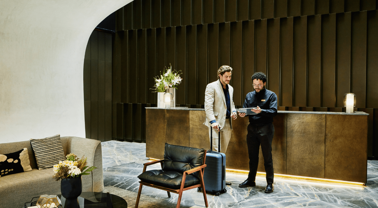 Hotel manager checking in business man in front of hotel reception desk