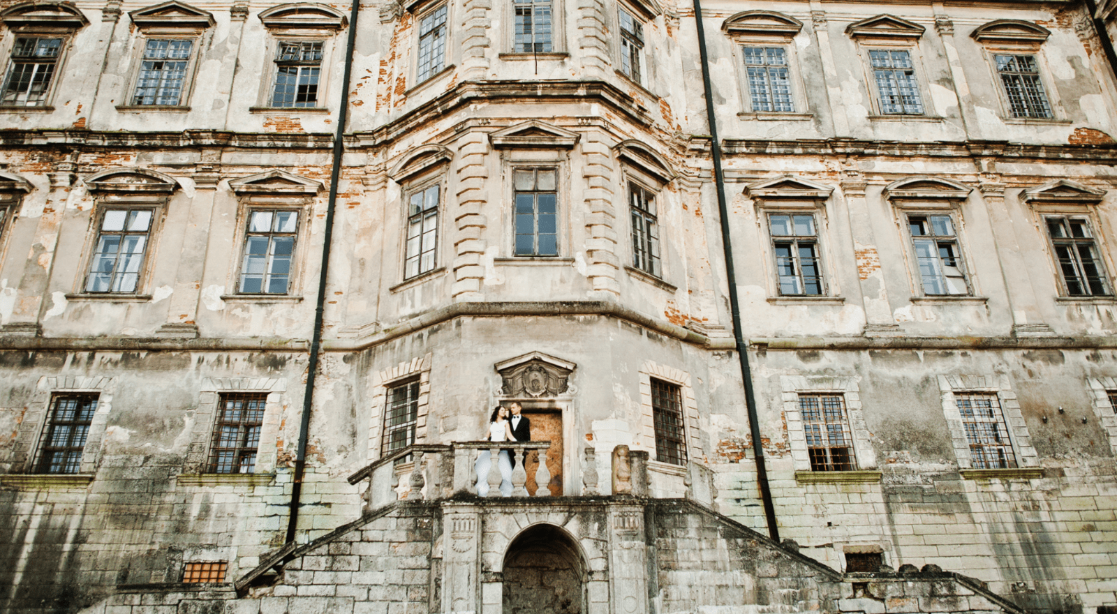 couple on their wedding day in front of castle