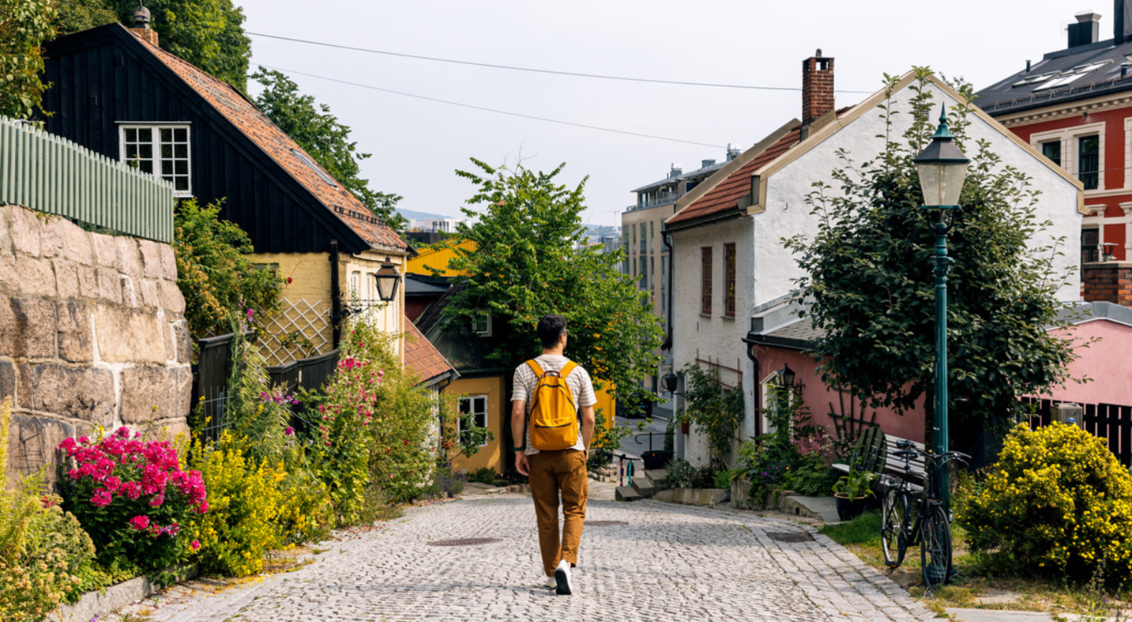 Rear view of a man with backpack walking in Oslo historical old town, Norway