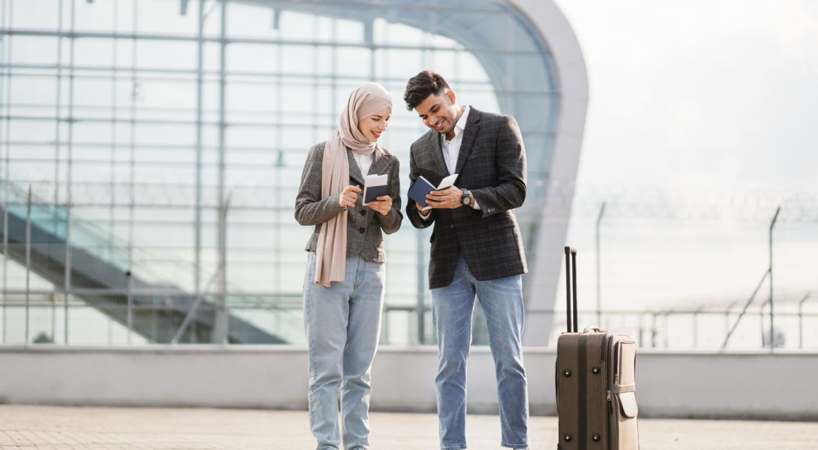 couple at airport with passports and suitcases