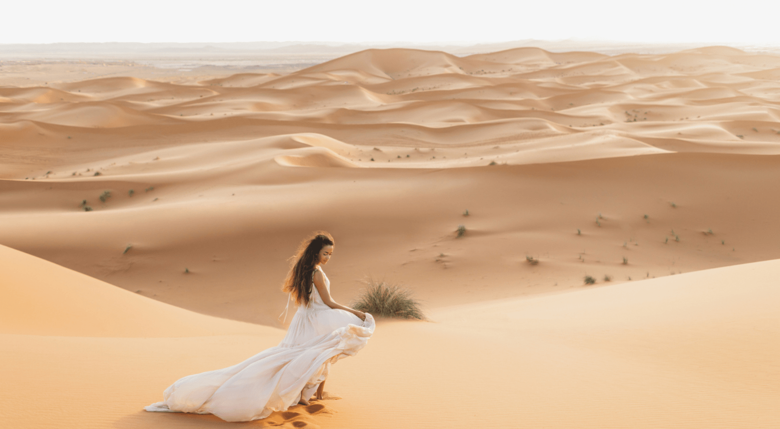 lady in white dress on sand dunes in morocco