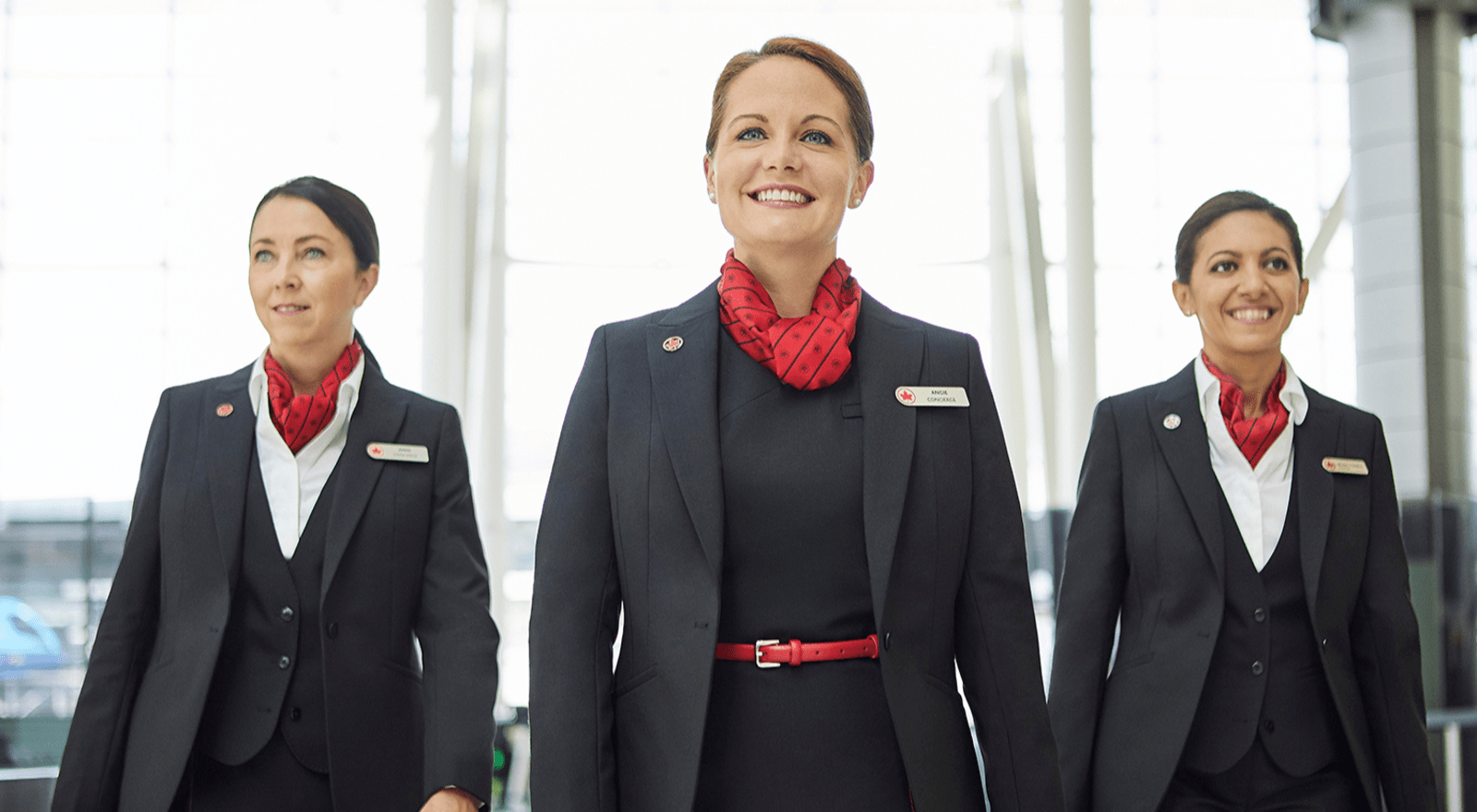 three ladies in air canada uniforms walking towards camera