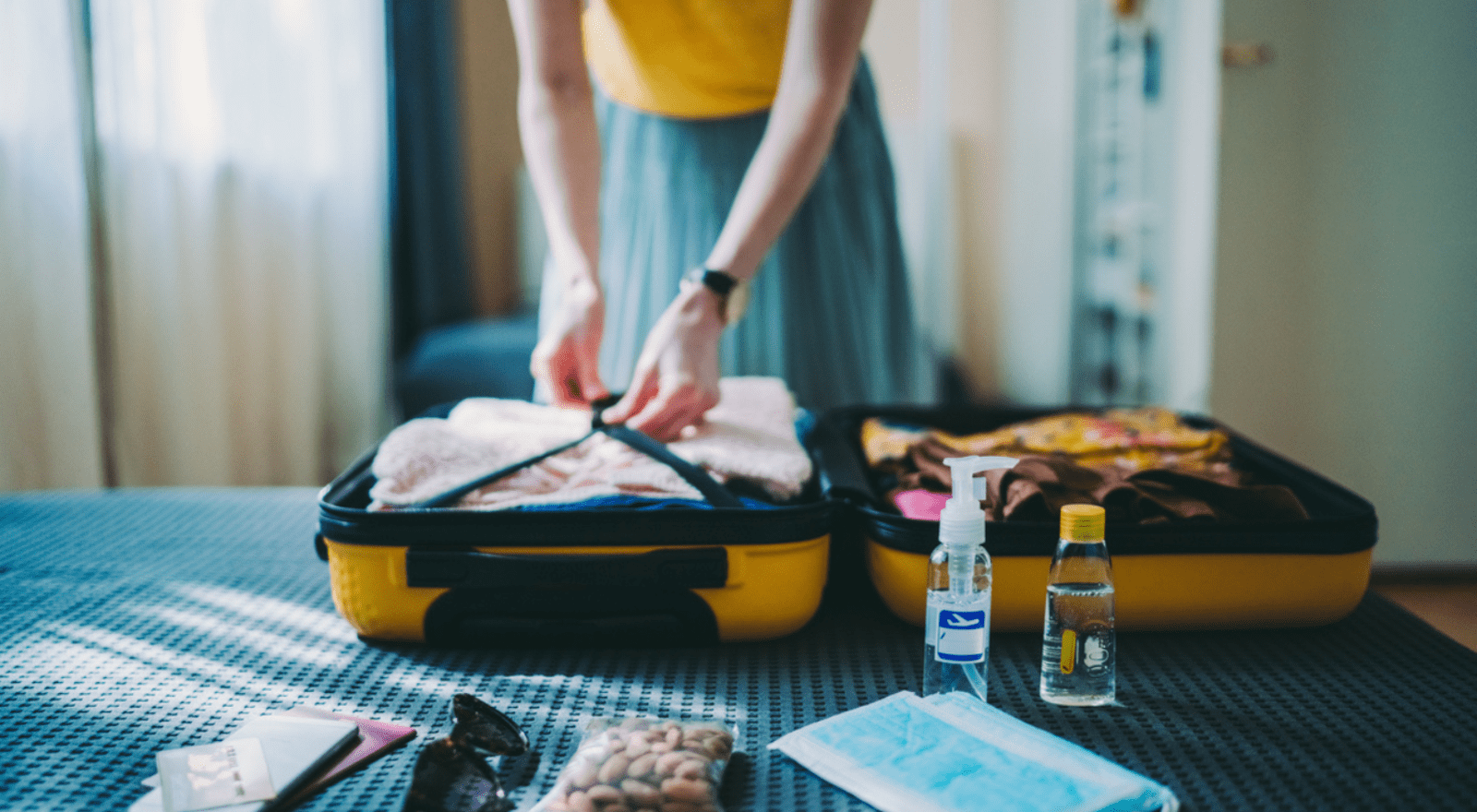 lady packing suitcase with toiletries
