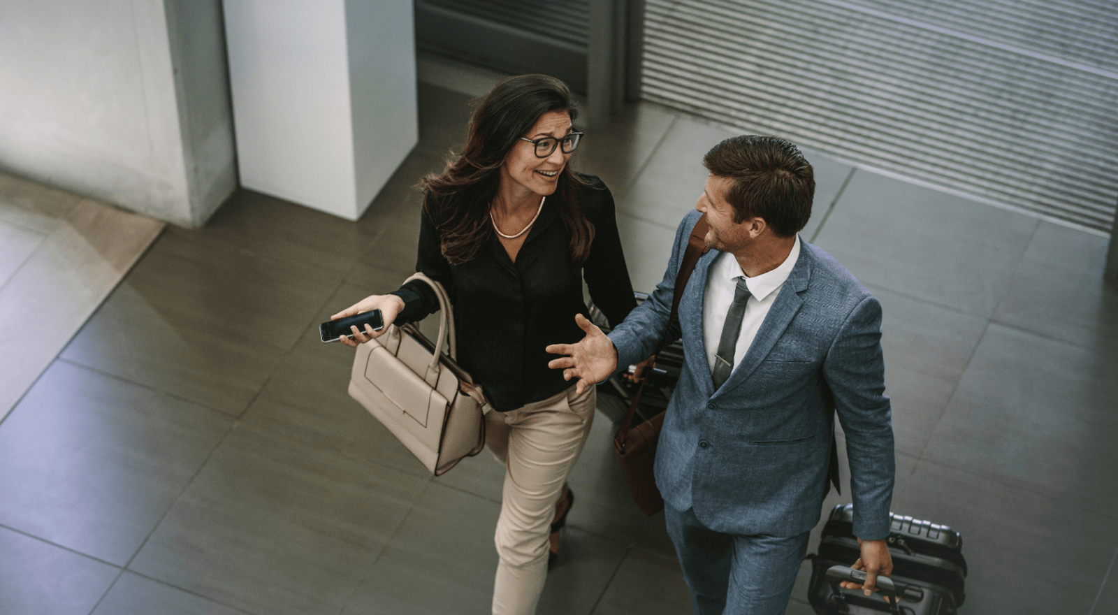 two business people smiling at each other when walking through lobby