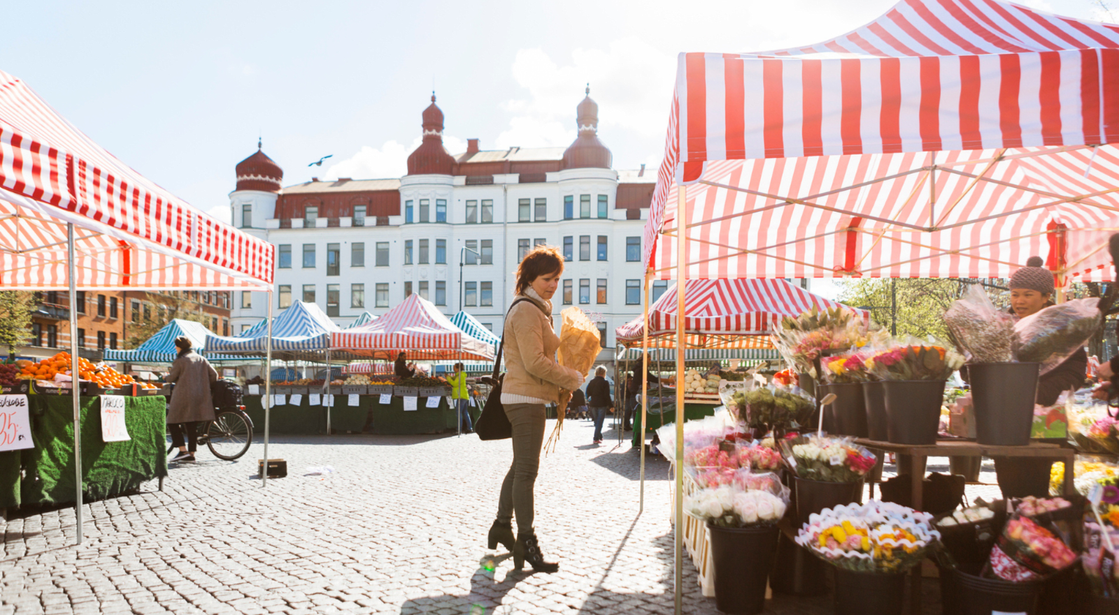 Lady buying flowers at market in europe