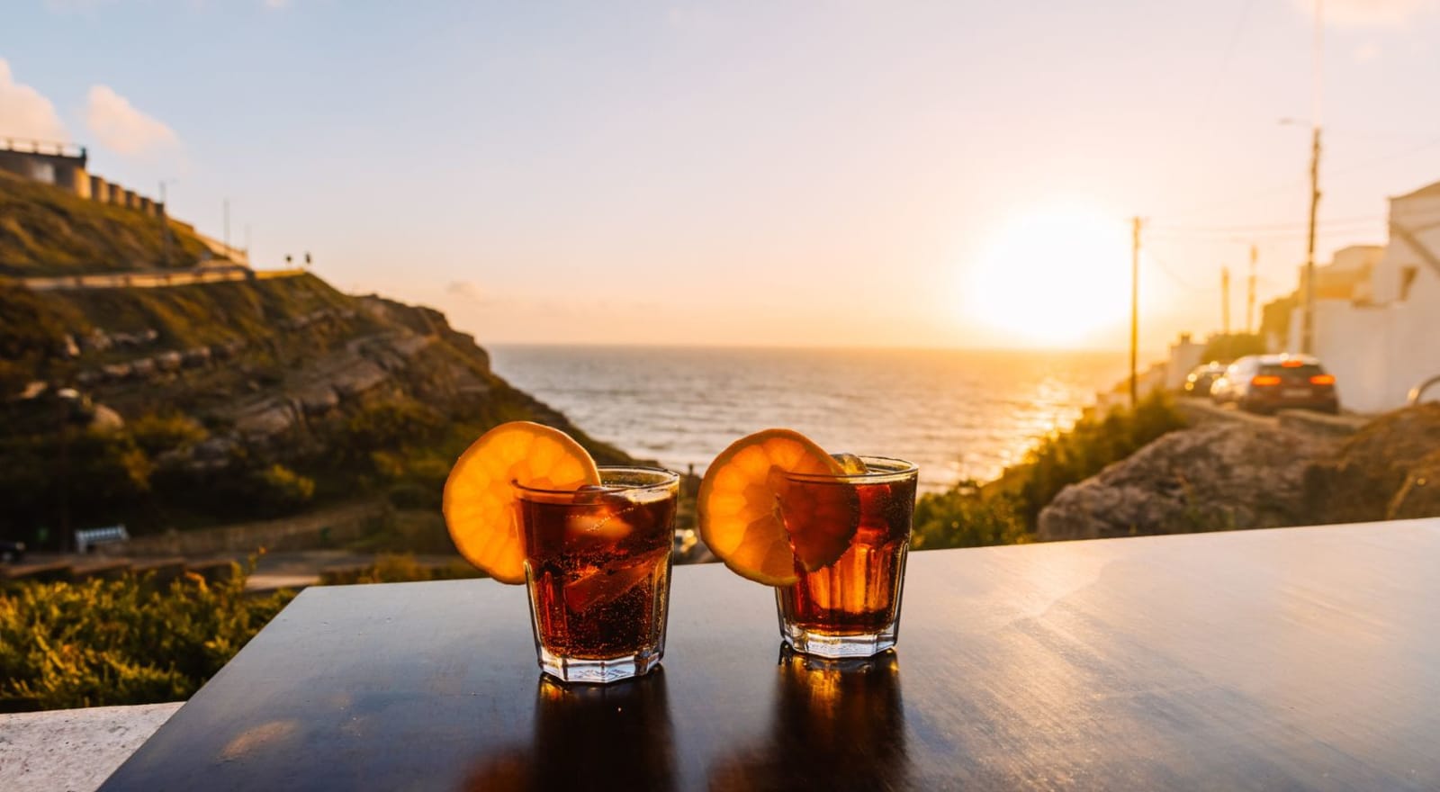 two cocktails on a table overlooking the ocean