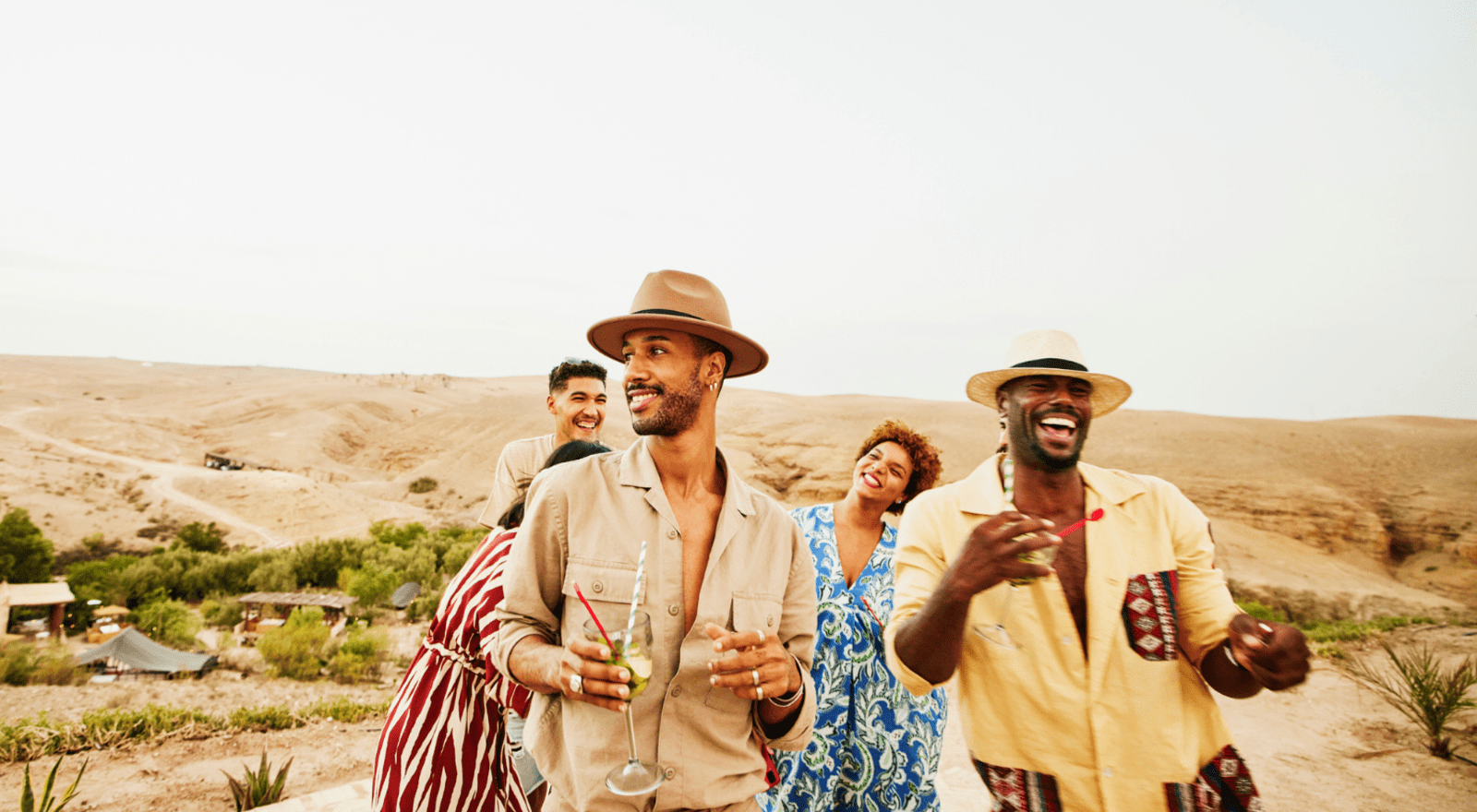 group of happy travellers holding drinks