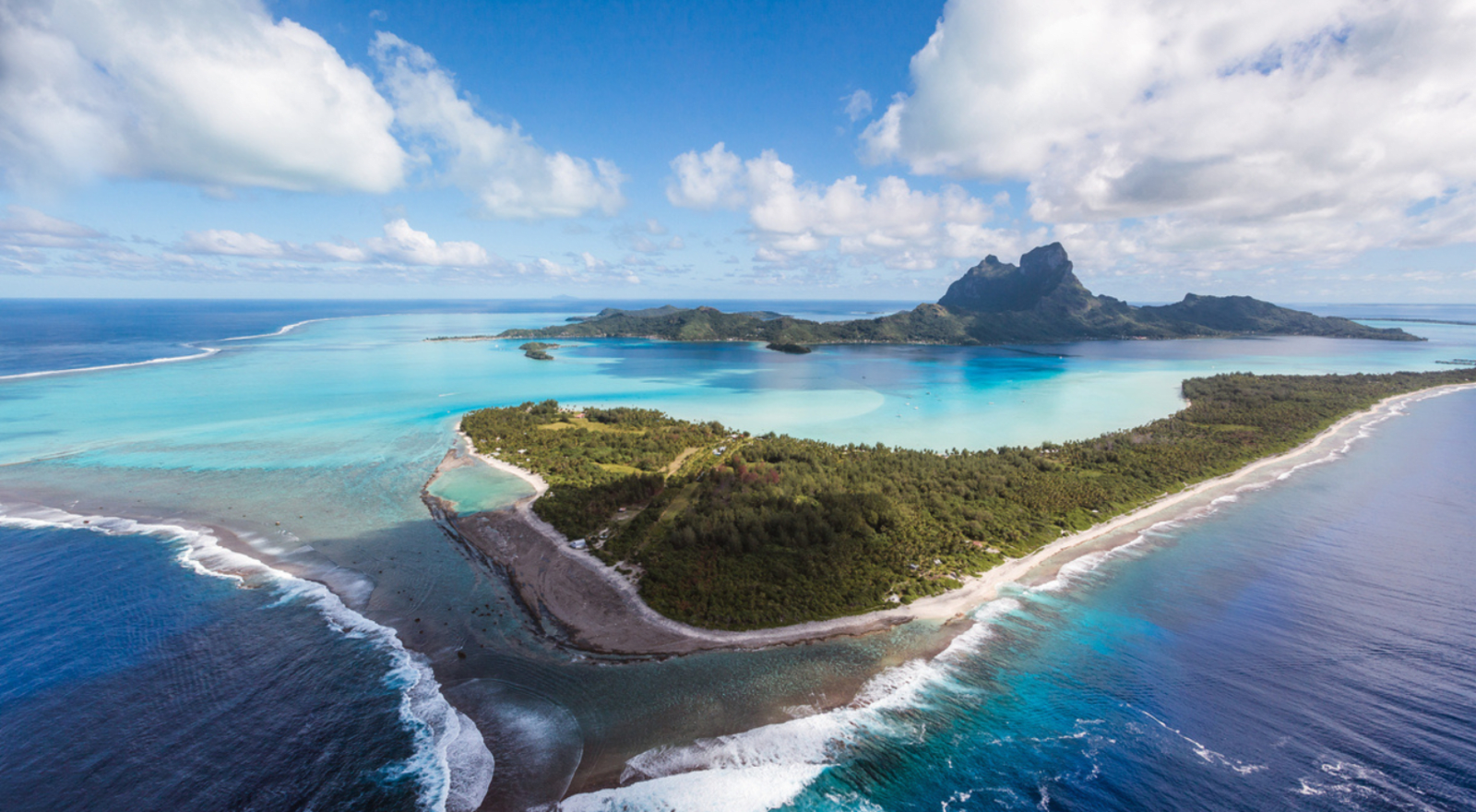 Aerial view of small islands surrounded by blue water and reefs