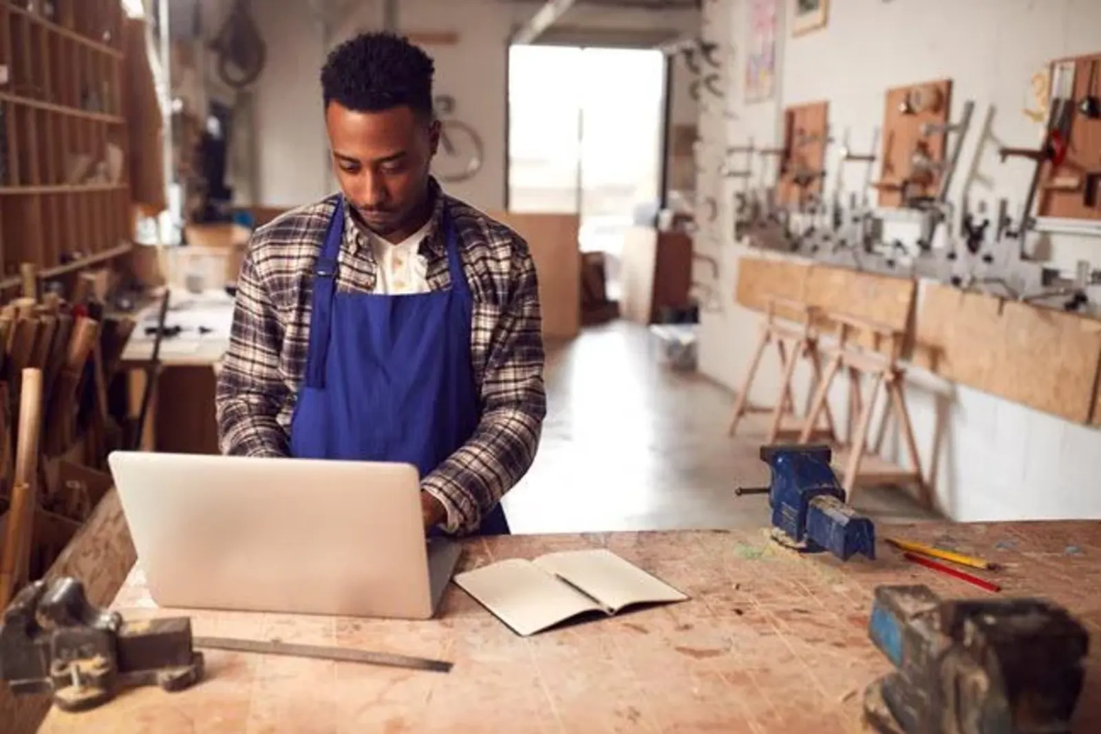 man using laptop in a workshop