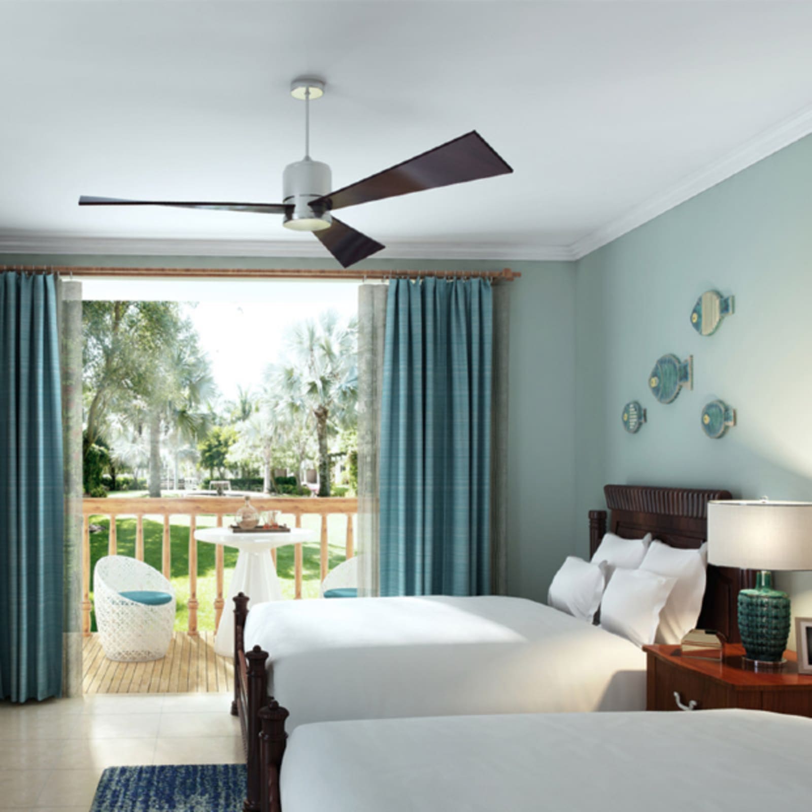 clean hotel room with open entryway leading to veranda looking over palm trees