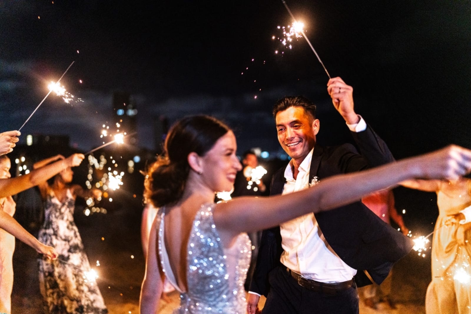 Bride and groom dancing with sparklers at beach wedding reception