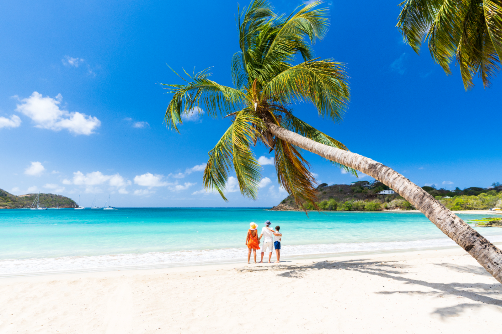 A mother and her two children standing on a beach in the Caribbean