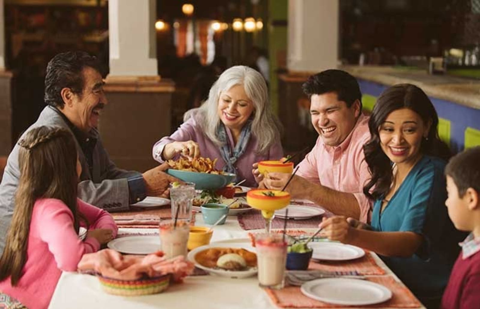 A family sitting together enjoying a feast of Mexican cuisine