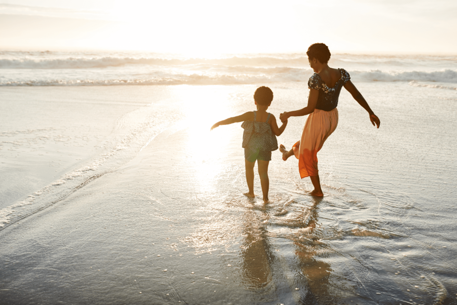 A mother and daughter splashing in the shallow waters at Historic Virginia Key Beach Park in Florida