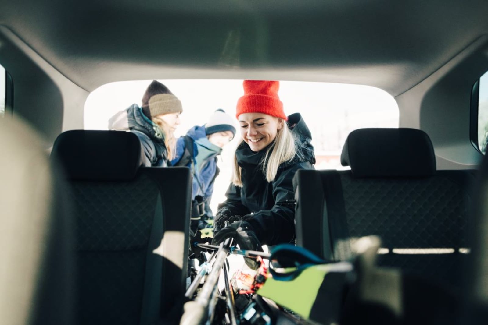 Friends packing up a car for a ski trip