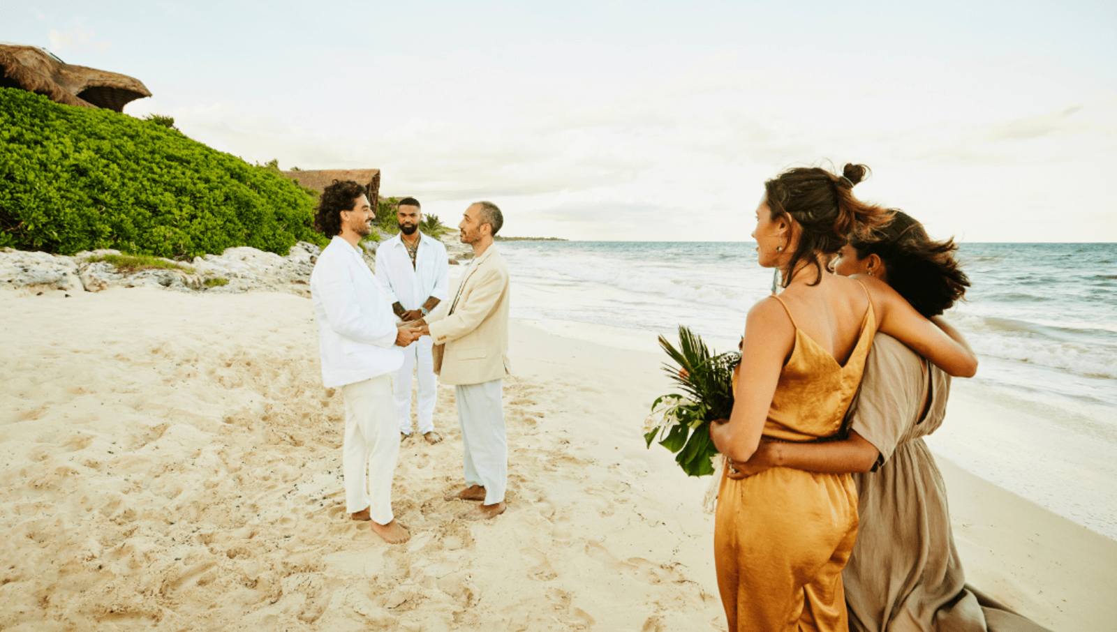 Queer couple gets married on private beach in Mexico with friends watching
