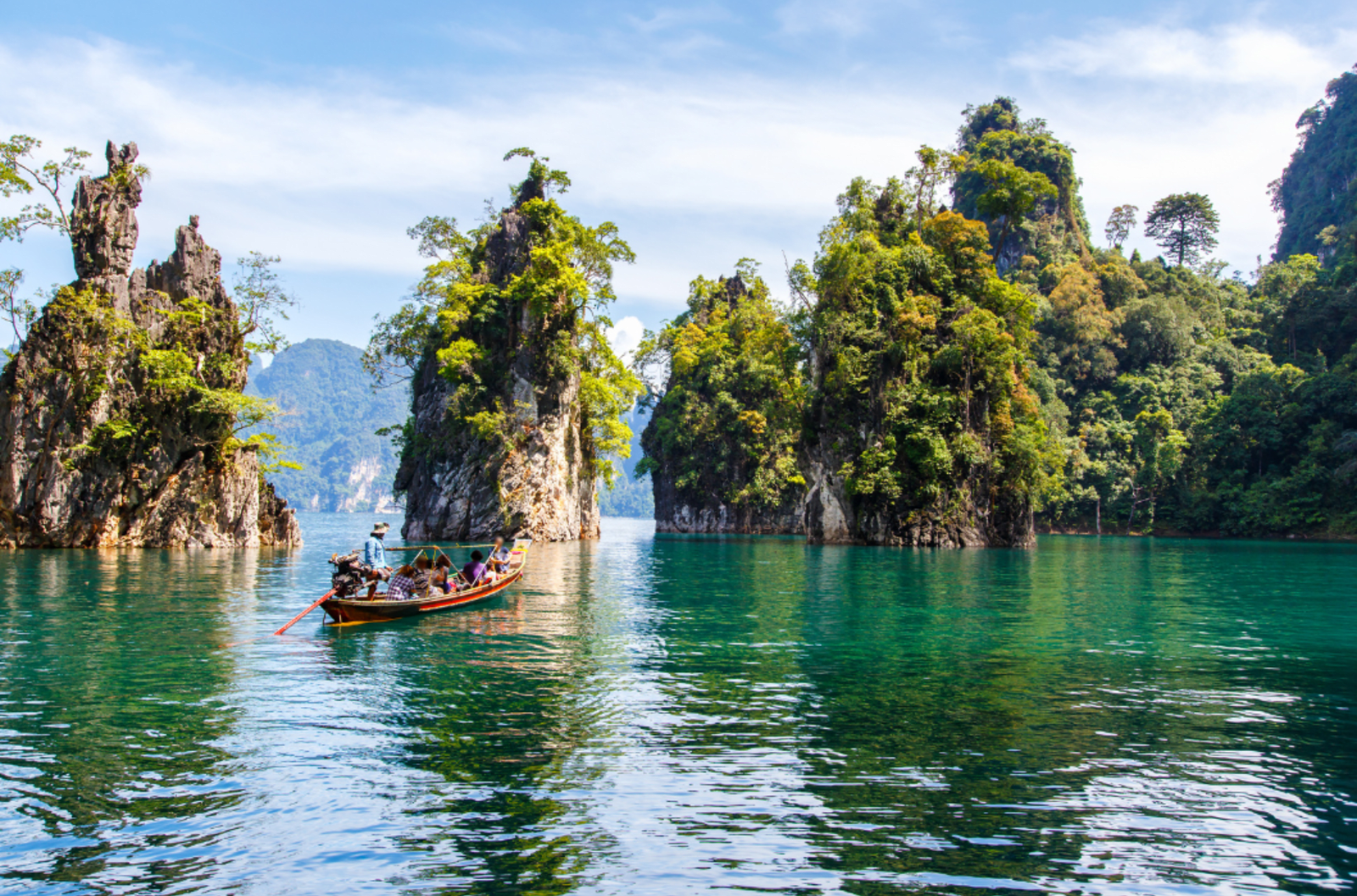 Clear blue waters surrounded by trees in Khao Sok National Park, Thailand.