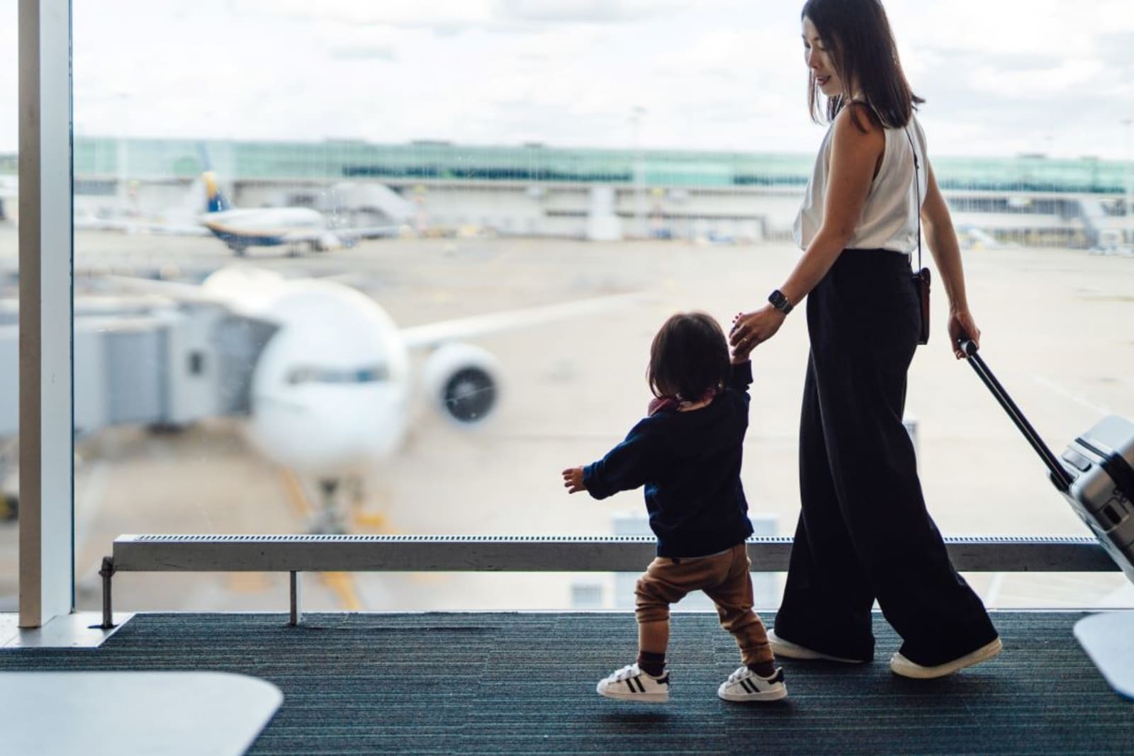 Mother and toddler walking in airport
