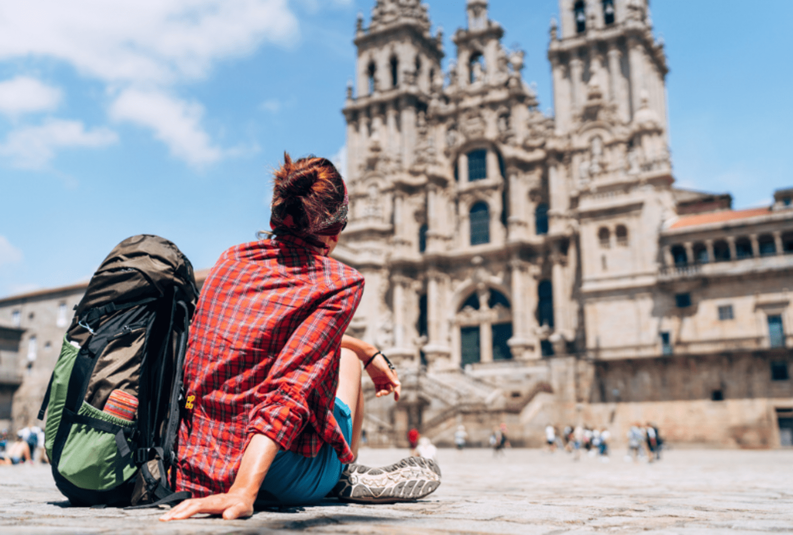 traveller sitting on ground in front of building in europe