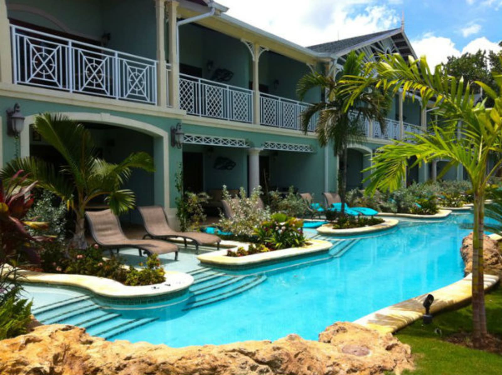 Luxury hotel pool with deck chairs and flowers