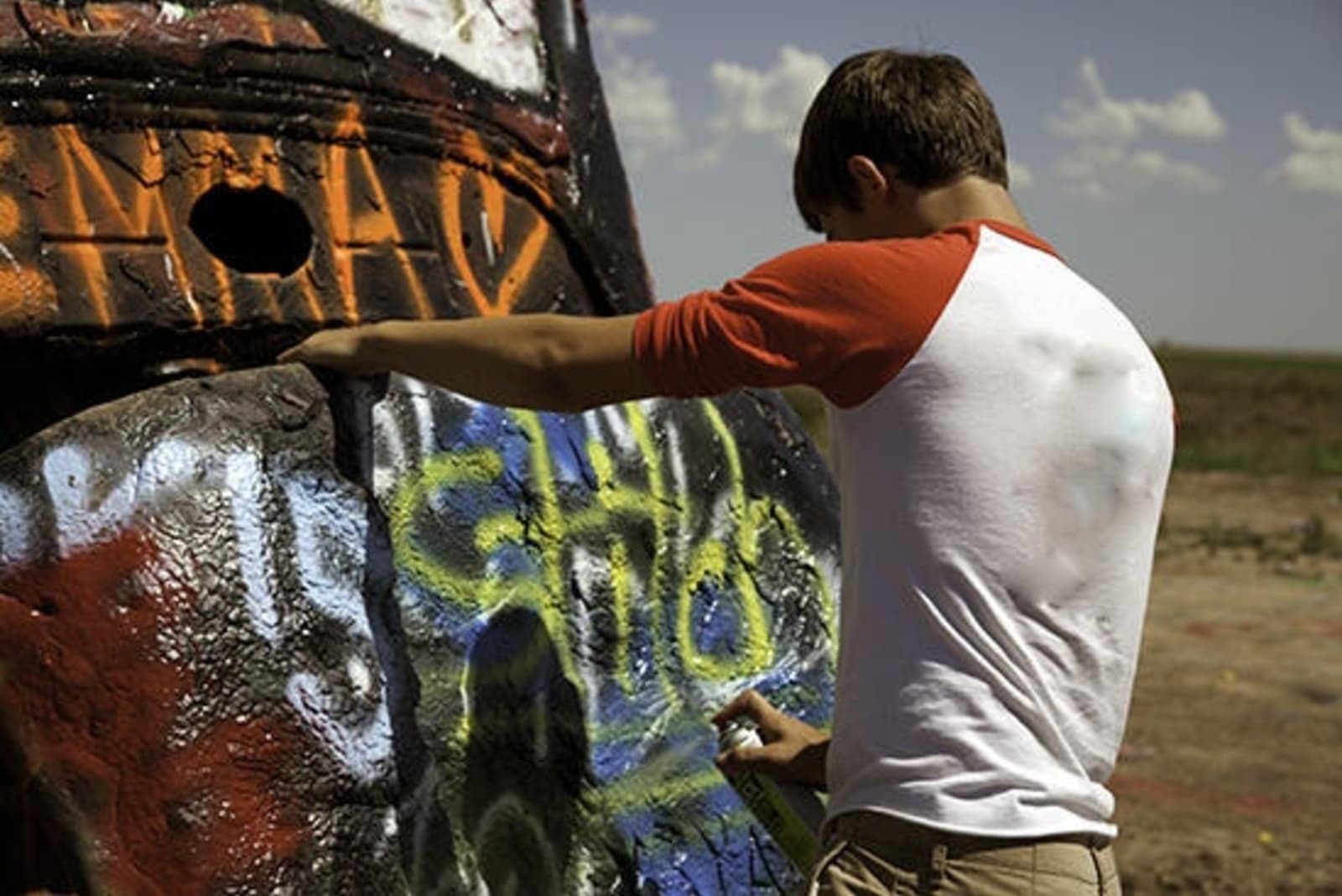 Man spray painting a Cadillac.