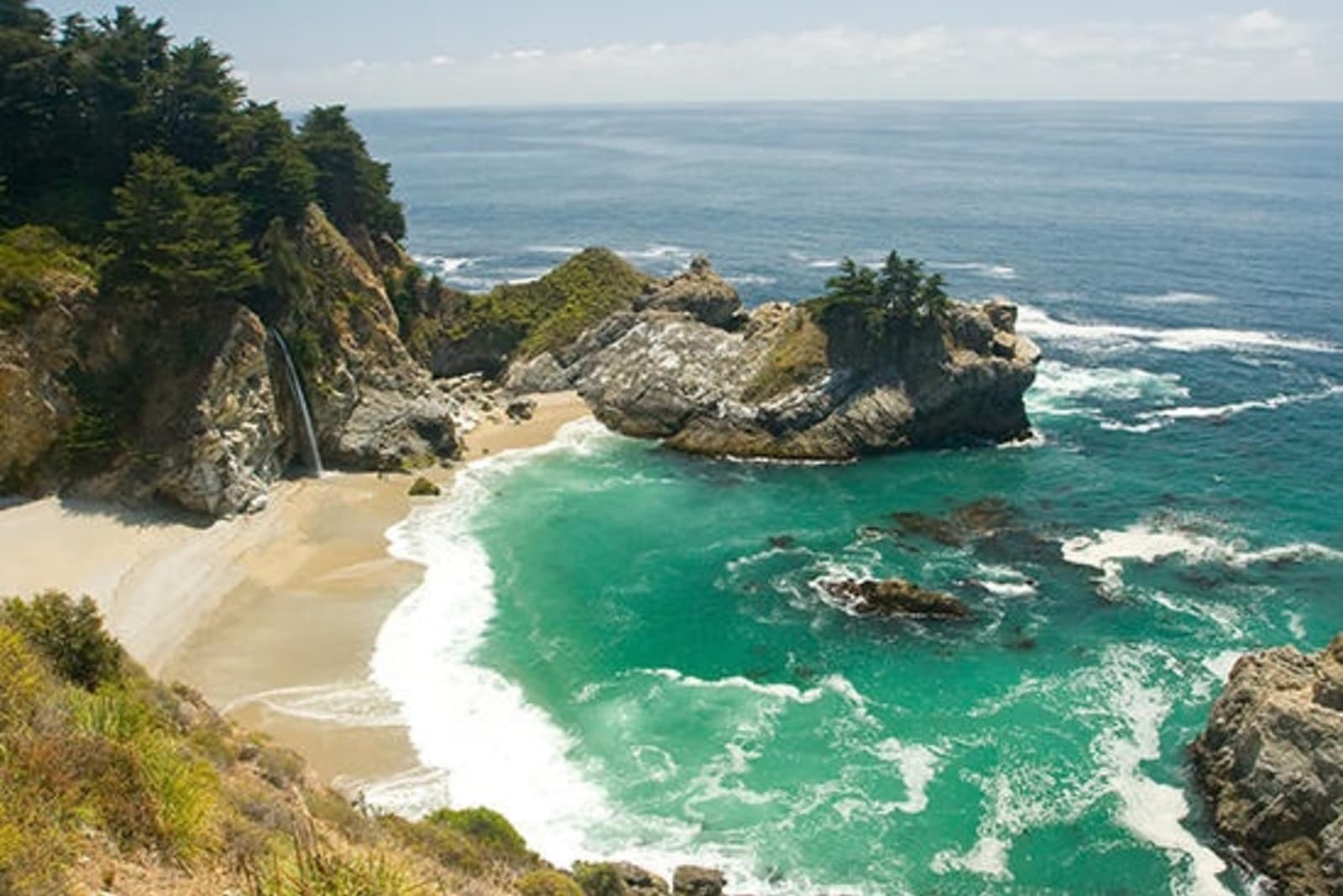Overlooking waves crashing on beach and rocks in Monterey, California.