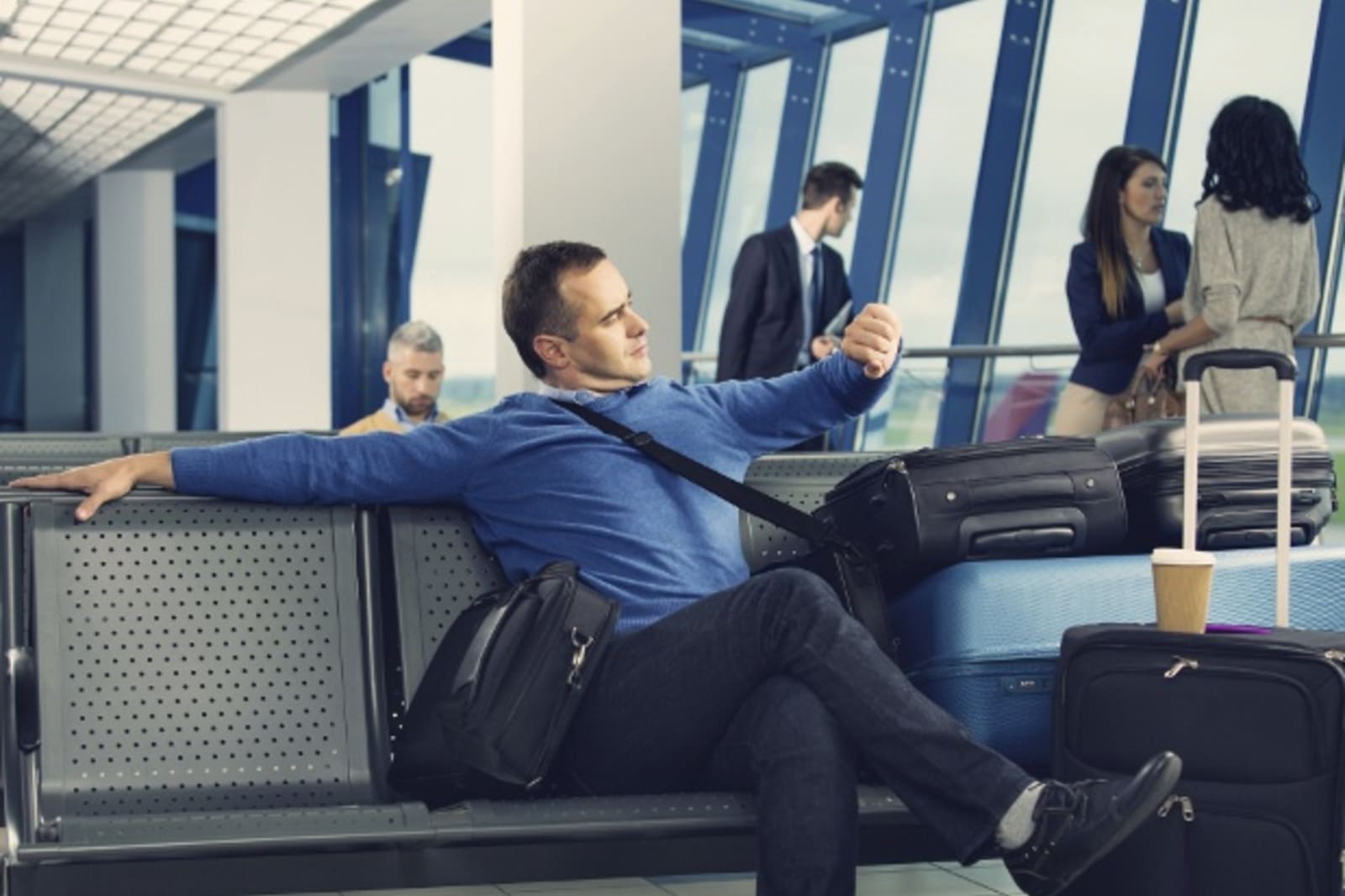 Man waiting at airport gate with luggage