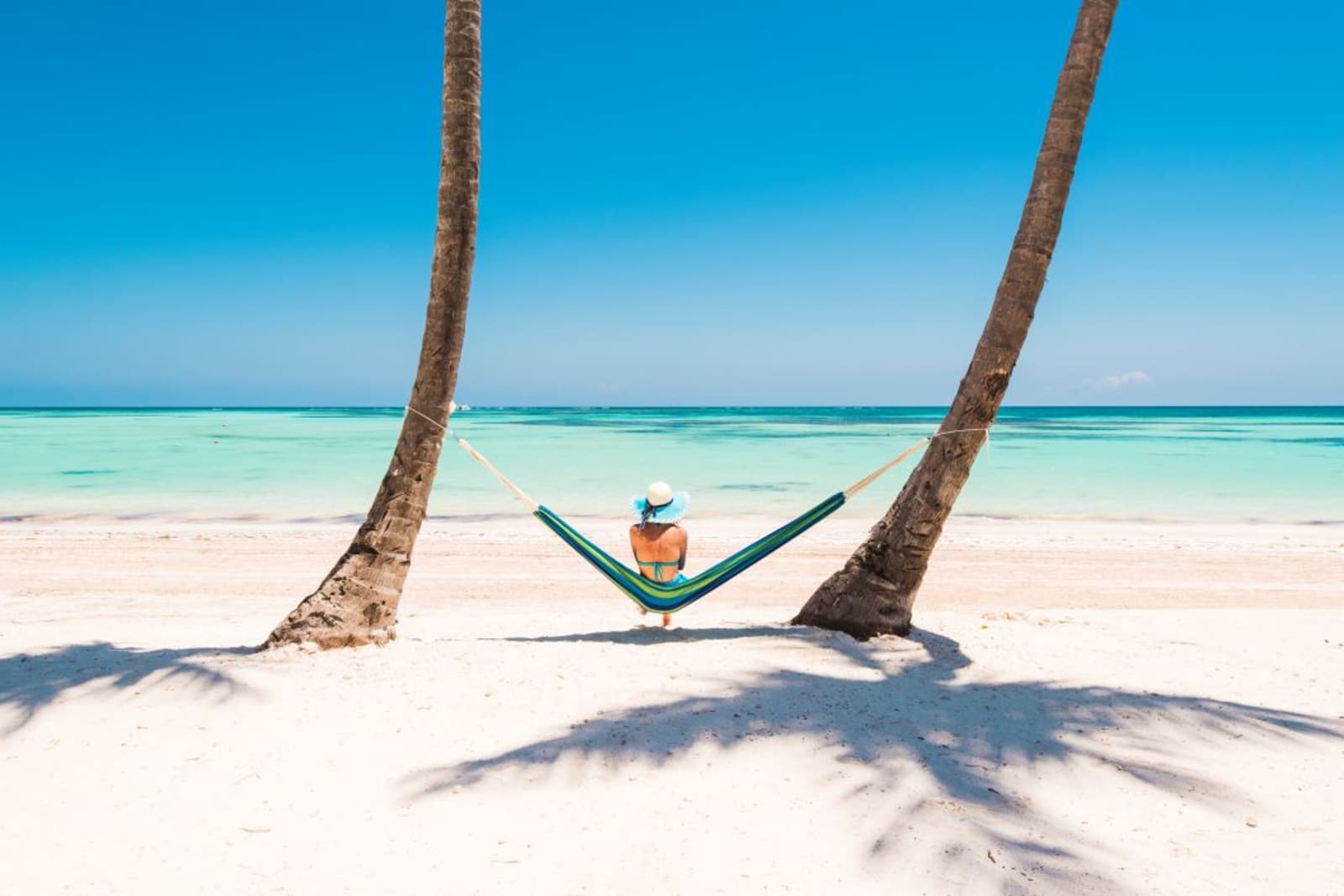 Woman relaxing in hammock on a pristine tropical beach