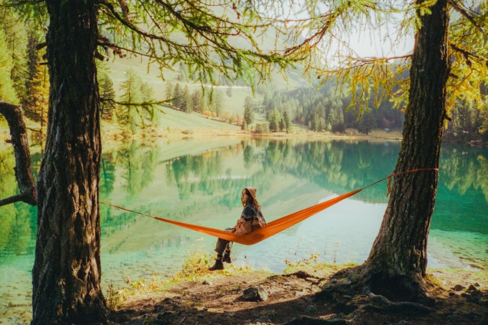 Woman in hammock in forested area of the Swiss Alps