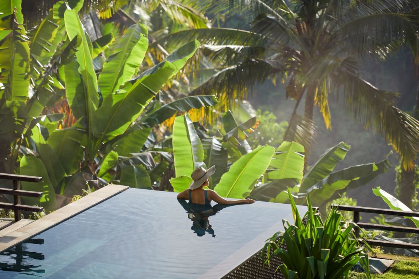 Woman in private pool in lush jungle area